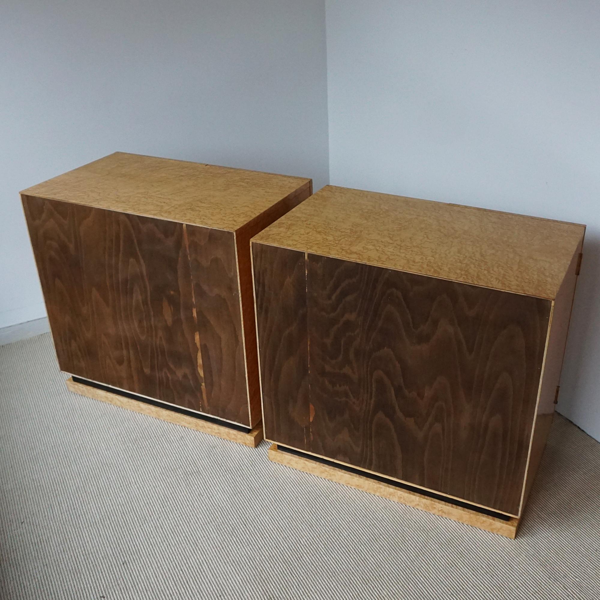 An Art Deco pair of console/side cabinets. Birdseye maple veneered throughout with an ebonised banding to base. Interior adjustable shelves. Original bakelite handles. 

