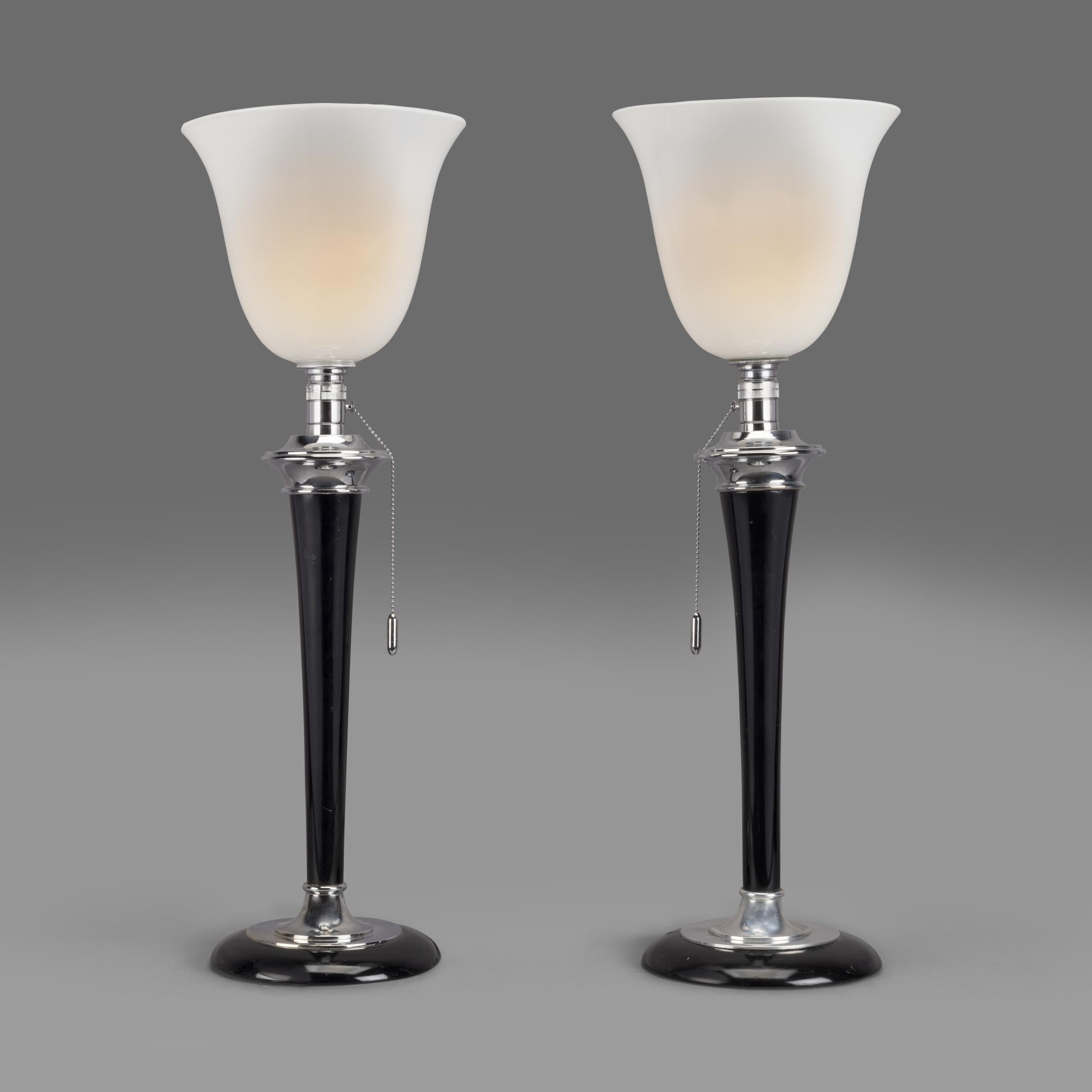An original pair of Art Deco 'Mazda' table lamps by Compagnie des Lampes de Paris.

Bearing a label to the base of one lamp for 'MAZDA'

These iconic Art Deco table lamps with their elegant profile, opaline shades, chrome fitments and ebonised