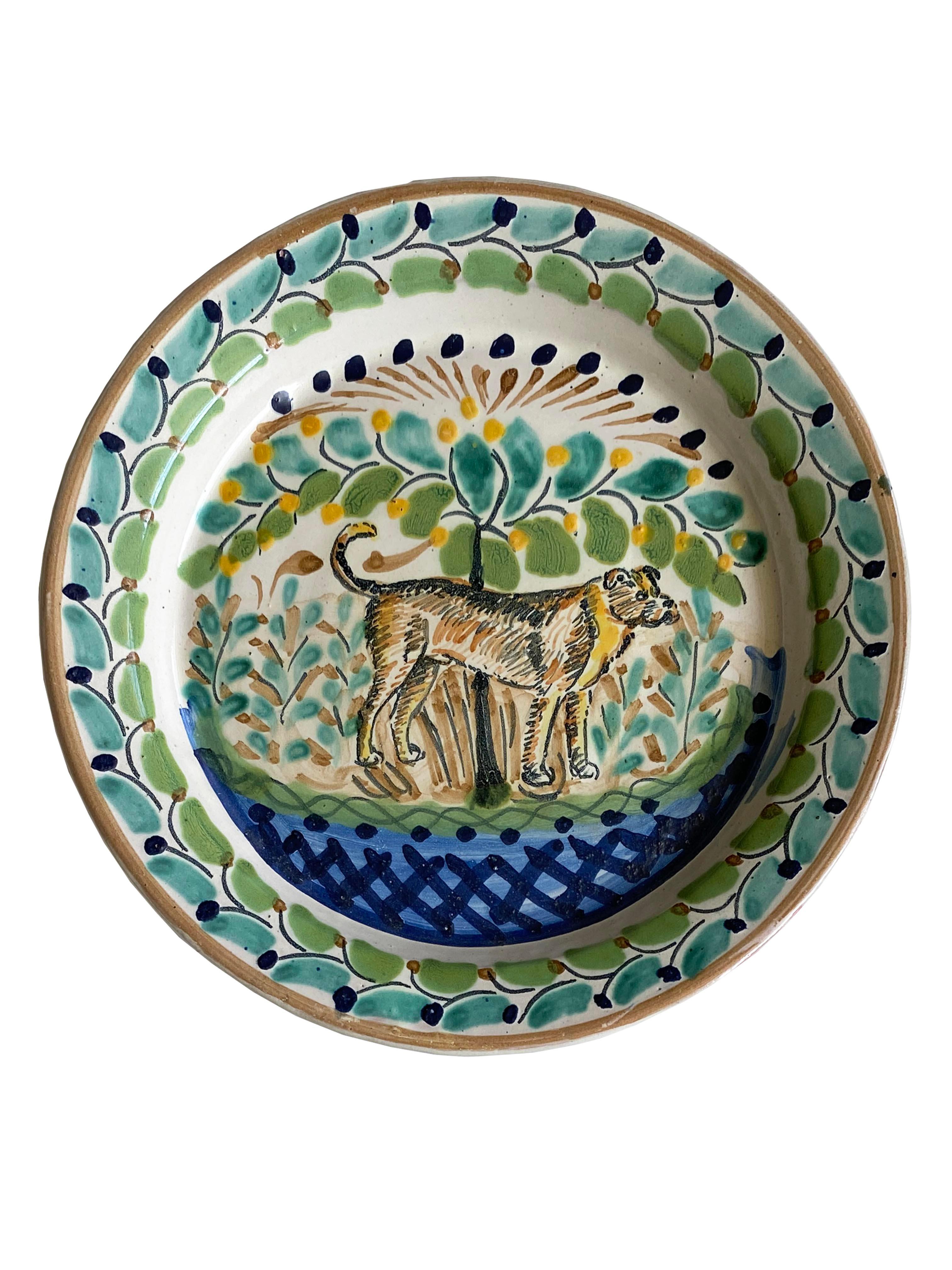 An original set of 2 hand-painted plates by Gorky Gonzalez. Each depicting a dog amidst vibrant floral motifs. Both plates bear the 