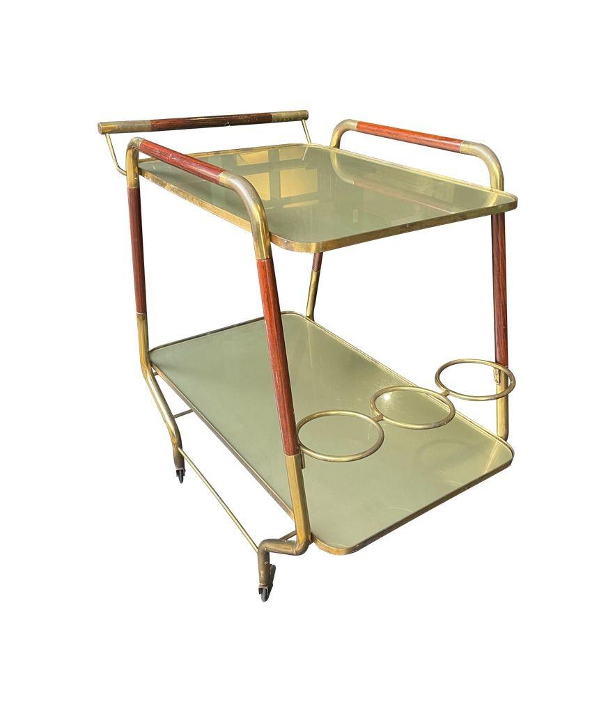 An original unusual design Italian 1950s lacquered wood and brass bar trolley by Cesare Lacca, with two orignal gold back painted glass shelves and orignal brass castors.