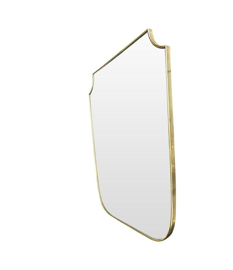 A 1950s Italian brass framed shield mirror with good proportions, as wider than normal ones of this size.