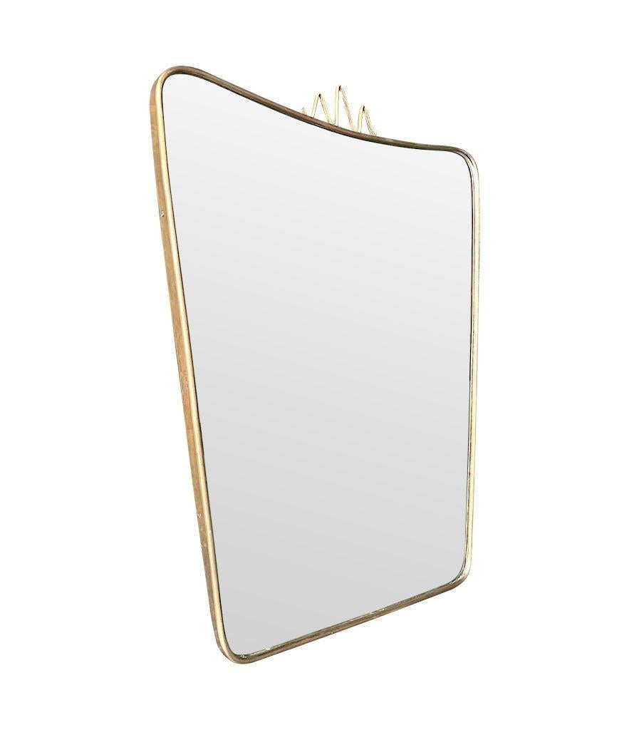 Miroir en laiton italien original des années 1950 dans le style de Gio Ponti avec des détails décoratifs sur le dessus, une plaque originale et un dos en bois massif.