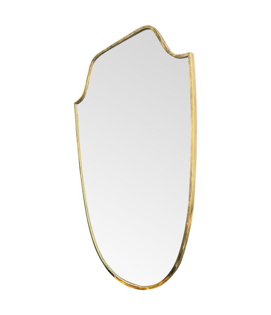 An orignal 1950s Italian shield mirror with solid brass frame and solid wood back