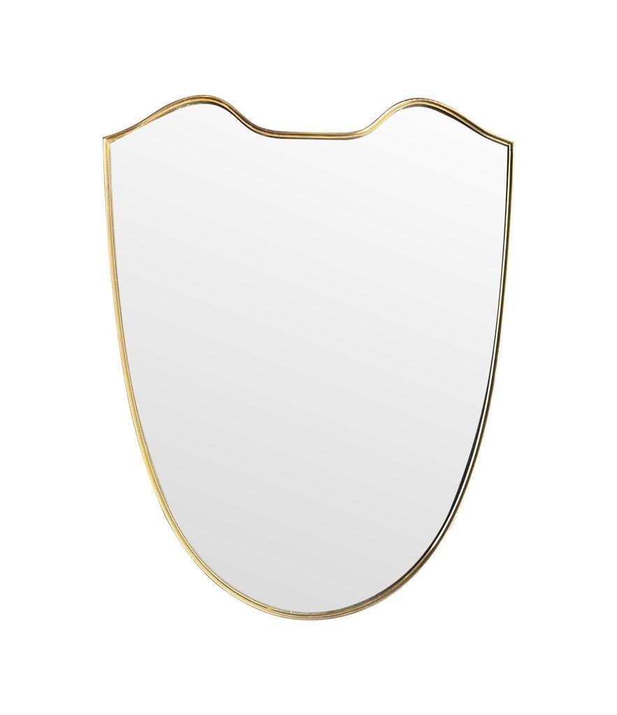 An orignal 1960s Italian shield mirror with brass frame.