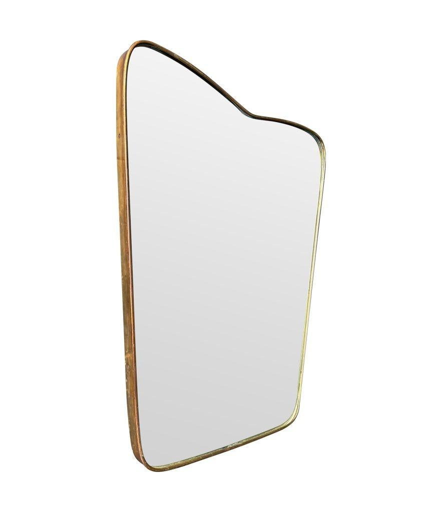 An orignal Italian 1950s brass frmed mirror with shaped top For Sale 1