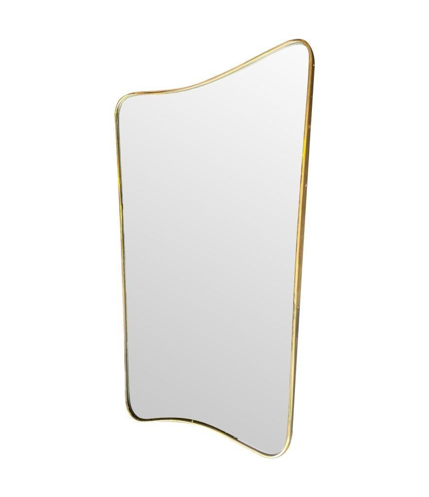 An orignal Italian 1950s brass shield mirror with wonderful curved top and base, with orginal brass levellers on the reverse attributed to Gio Ponti