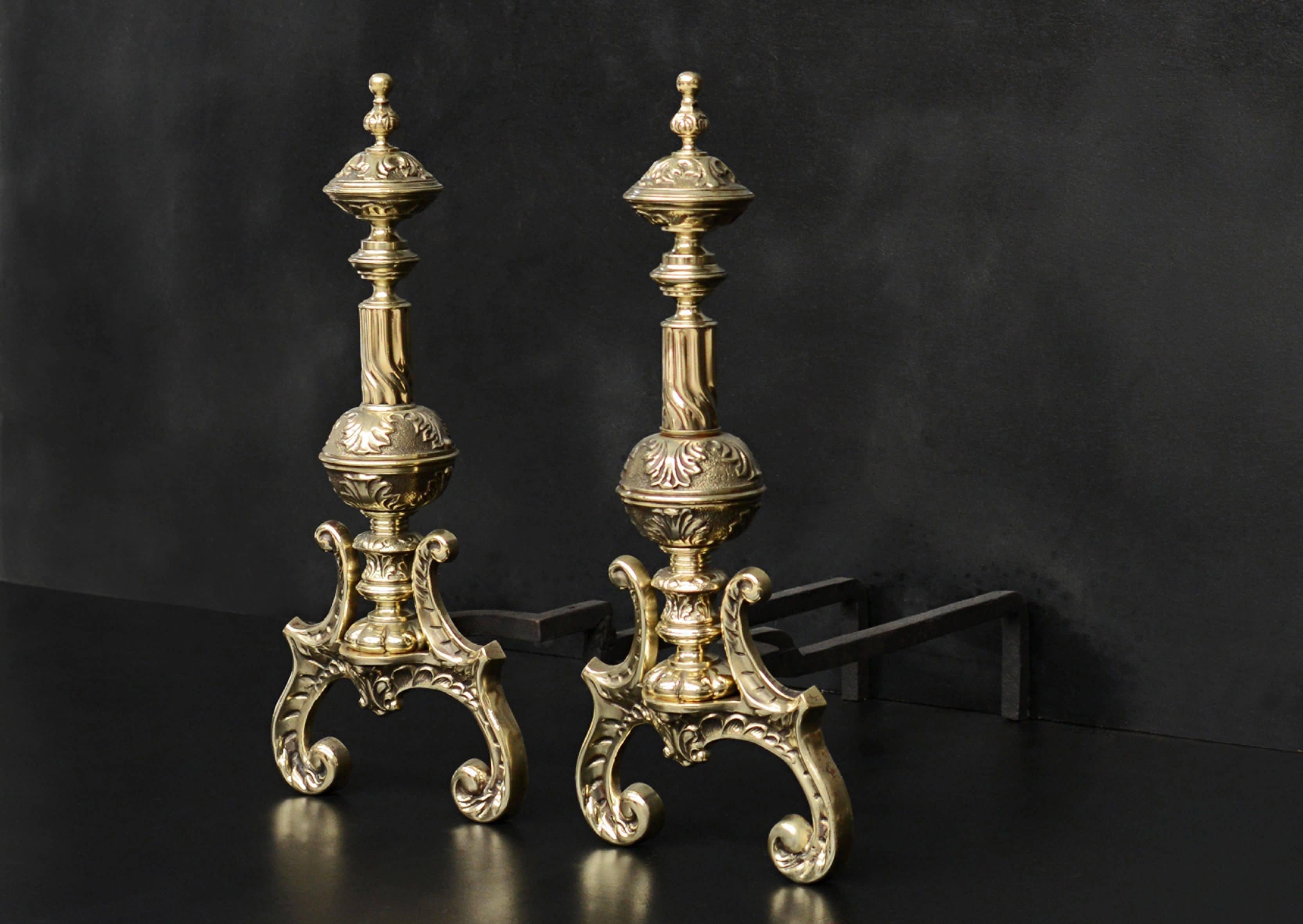 An ornate pair of brass firedogs. The arched and scrolled feet with finely cast foliage above. 19th century.

Measures: Height: 550 mm 21 ?