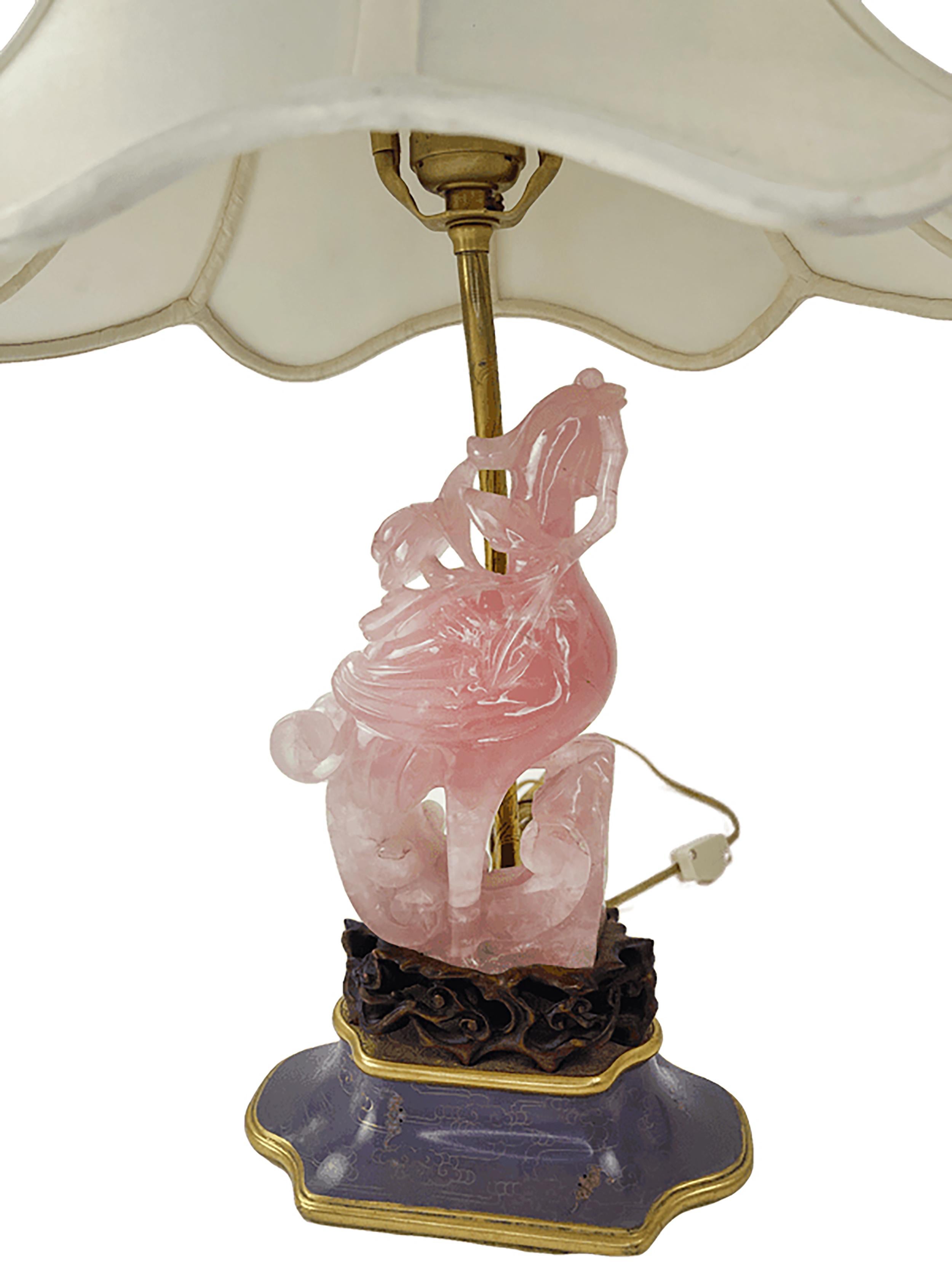 About:
A beautifully ornate pink quartz lamp. Hand carved pink quartz figure in the center with a brass rod holding the light below the lamp shade. Wood carved base painted in lacquer finish and gilt detailing.

We believe a chinese phoenix