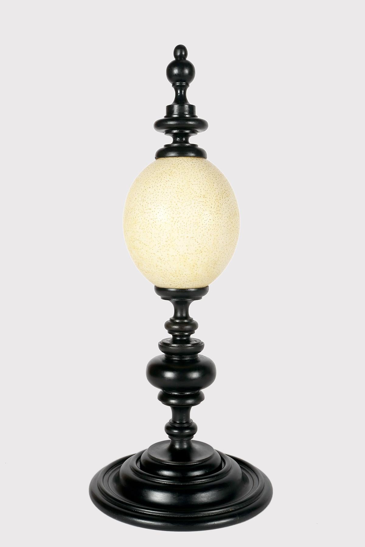 A specimen of Naturalia an ostrich egg (Struthio camelus)  mounted on an ebonized wooden base. The upper part, mounted on the summit, in the shape of a pinnacle, always of the same wood and color as the base. Italy 1900. (SHIP TO EU ONLY)