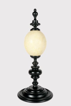 Huevo de avestruz de una wunderkammer, con base de madera ebonizada, Italia 1900.