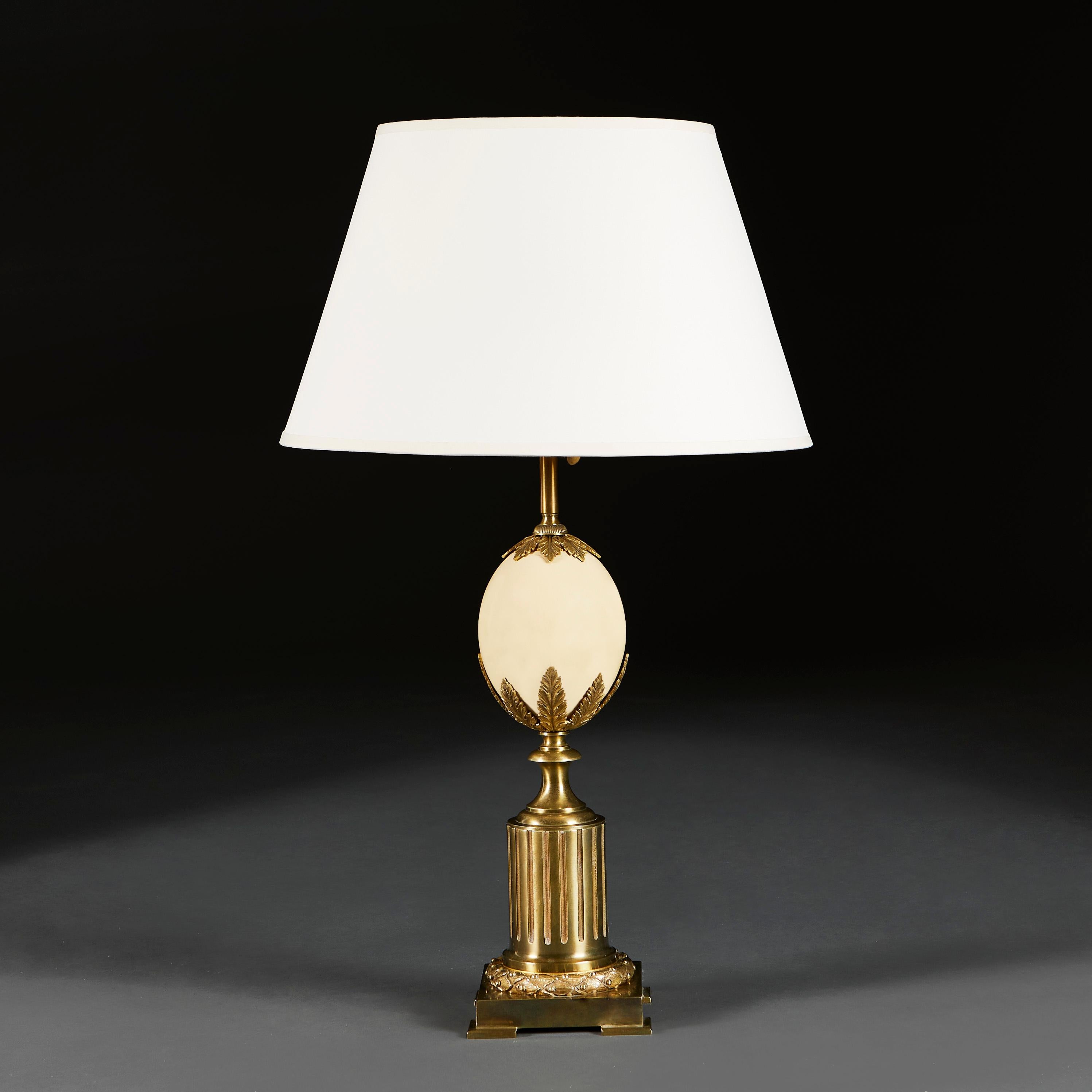 France, vers 1940

Une grande lampe en laiton avec un oeuf d'autruche soutenu par une gerbe de feuilles d'acanthe, le tout soutenu par un cylindre à godrons sur une base carrée avec un rond de feuilles de laurier.

Hauteur de la lampe