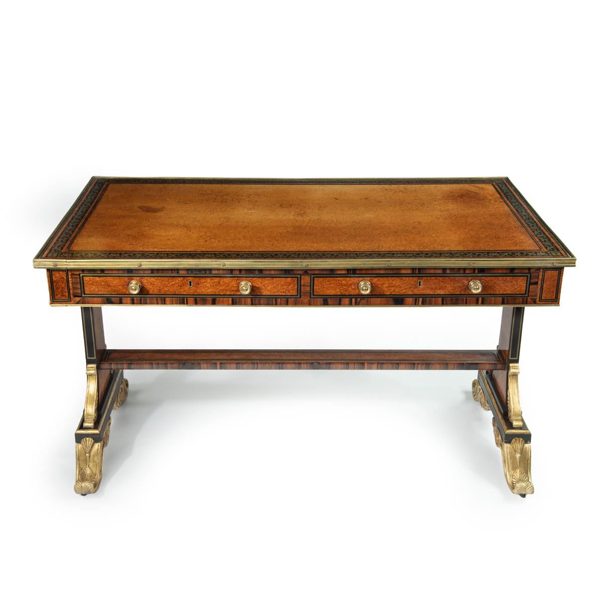 This outstanding and important writing table has a rectangular top above two cedar-lined frieze drawers.  It is raised on rectangular section flared end supports with parcel gilt and ebonised scroll spandrels and feet joined by a flat brass inlaid