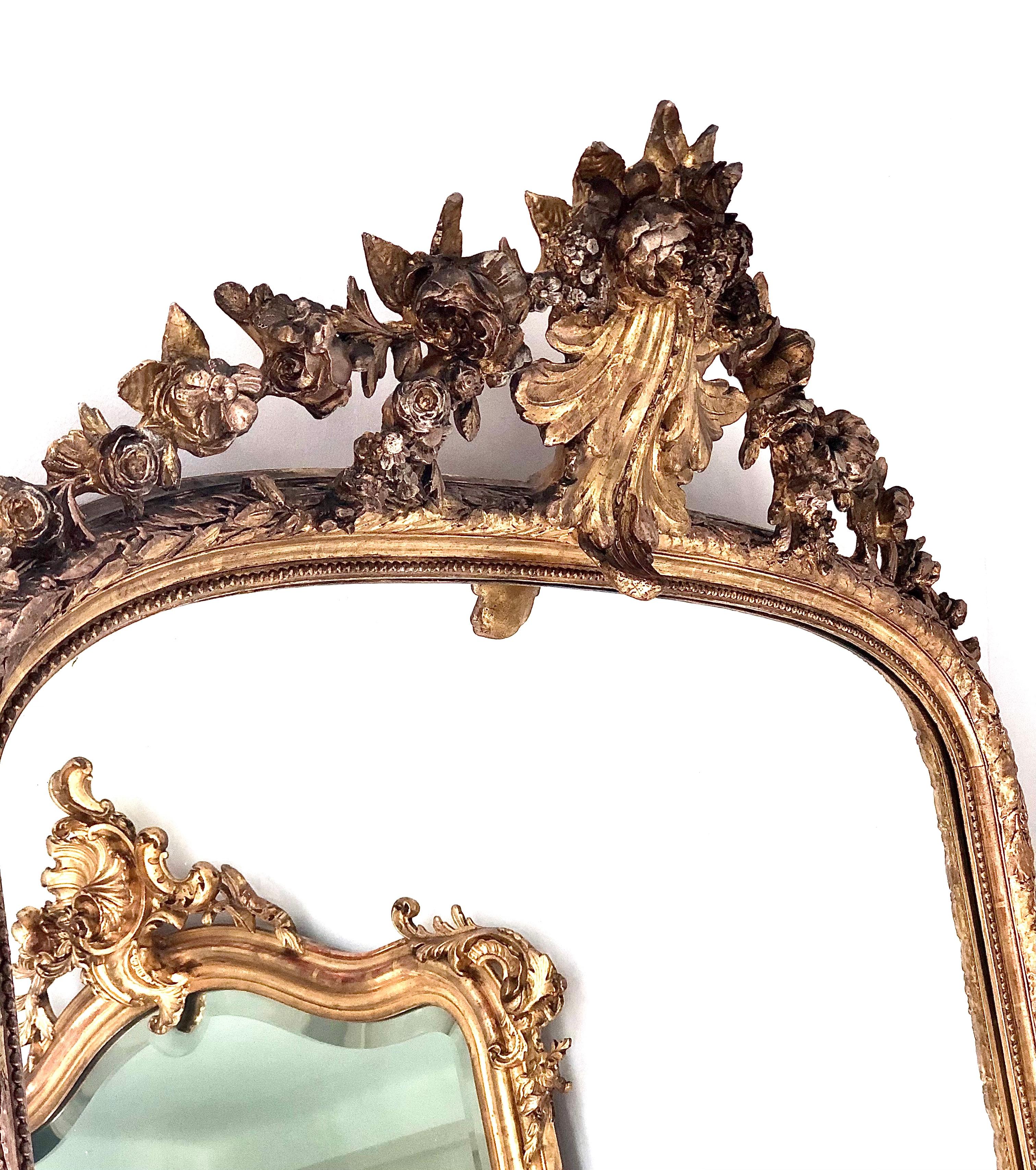 Ein eleganter französischer Spiegel aus vergoldetem Holz im Stil Ludwigs XVI. aus der Zeit Napoleons III., der die ursprüngliche Spiegelplatte beibehält. Der breite Rahmen ist mit einer Perlenkette und einem Olivenbaumblatt verziert und wird von