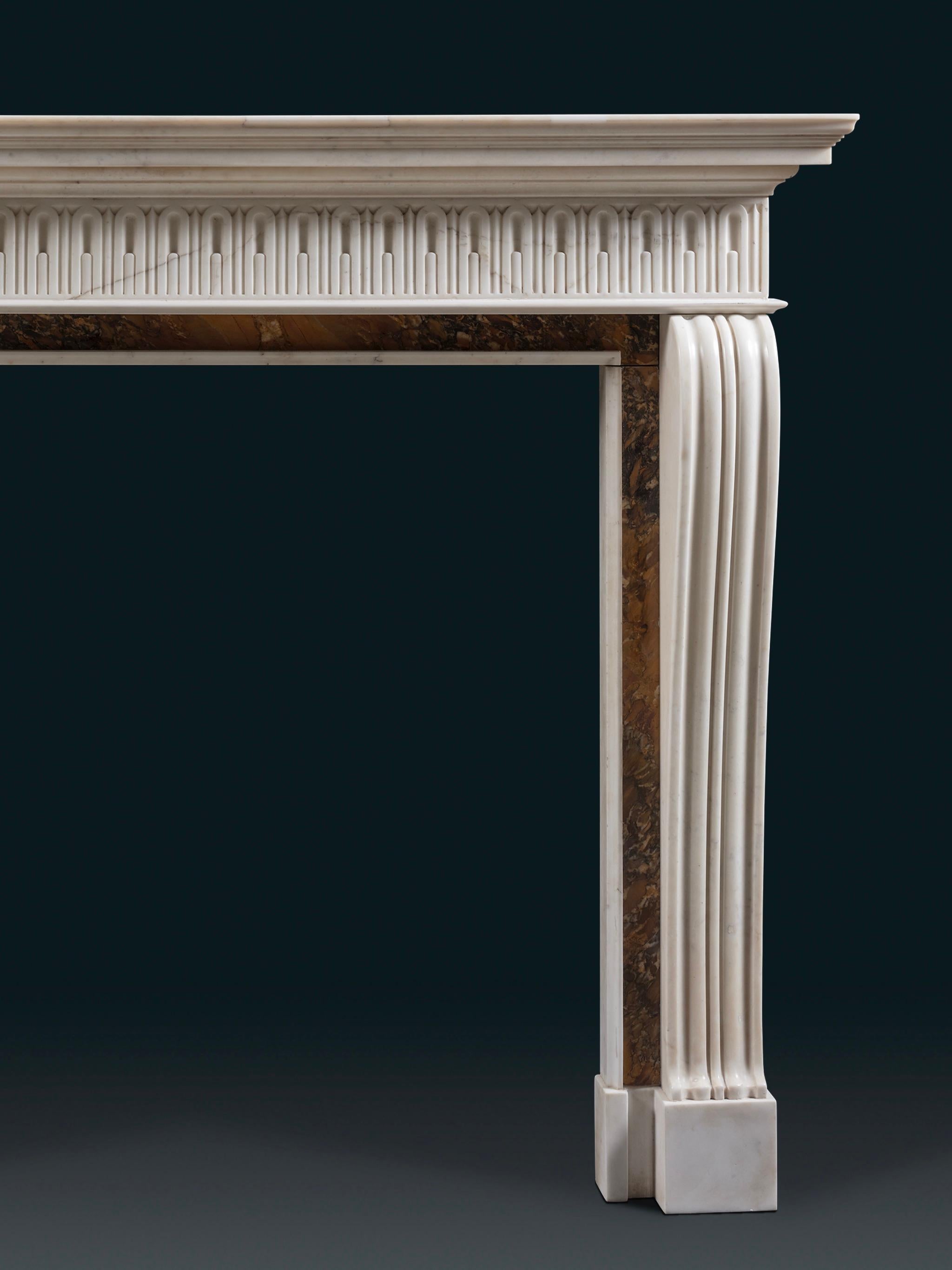 With a tiered moulded shelf, a frieze with stopped finger flutes and the inground veneered in Convent Sienna marble, supported on console jambs. In 1731 Isaac Ware shows a design very similar to this chimneypiece in his ‘Designs of Inigo Jones’,