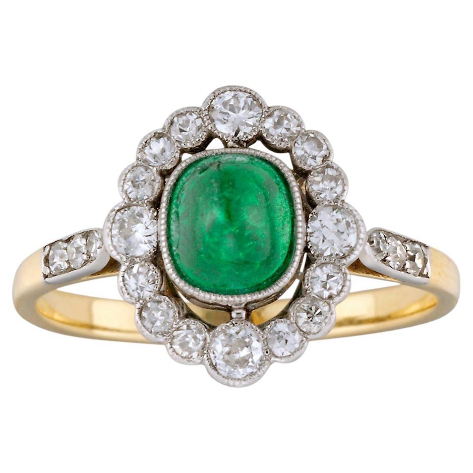 Ein ovaler Smaragd- und Diamant-Cluster-Ring