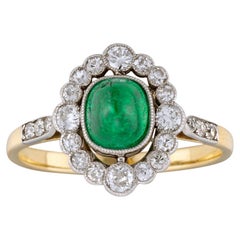 An Oval Emerald And Diamond Cluster Ring