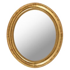 An Oval Giltwood Mirror with Inner Beading Molding
