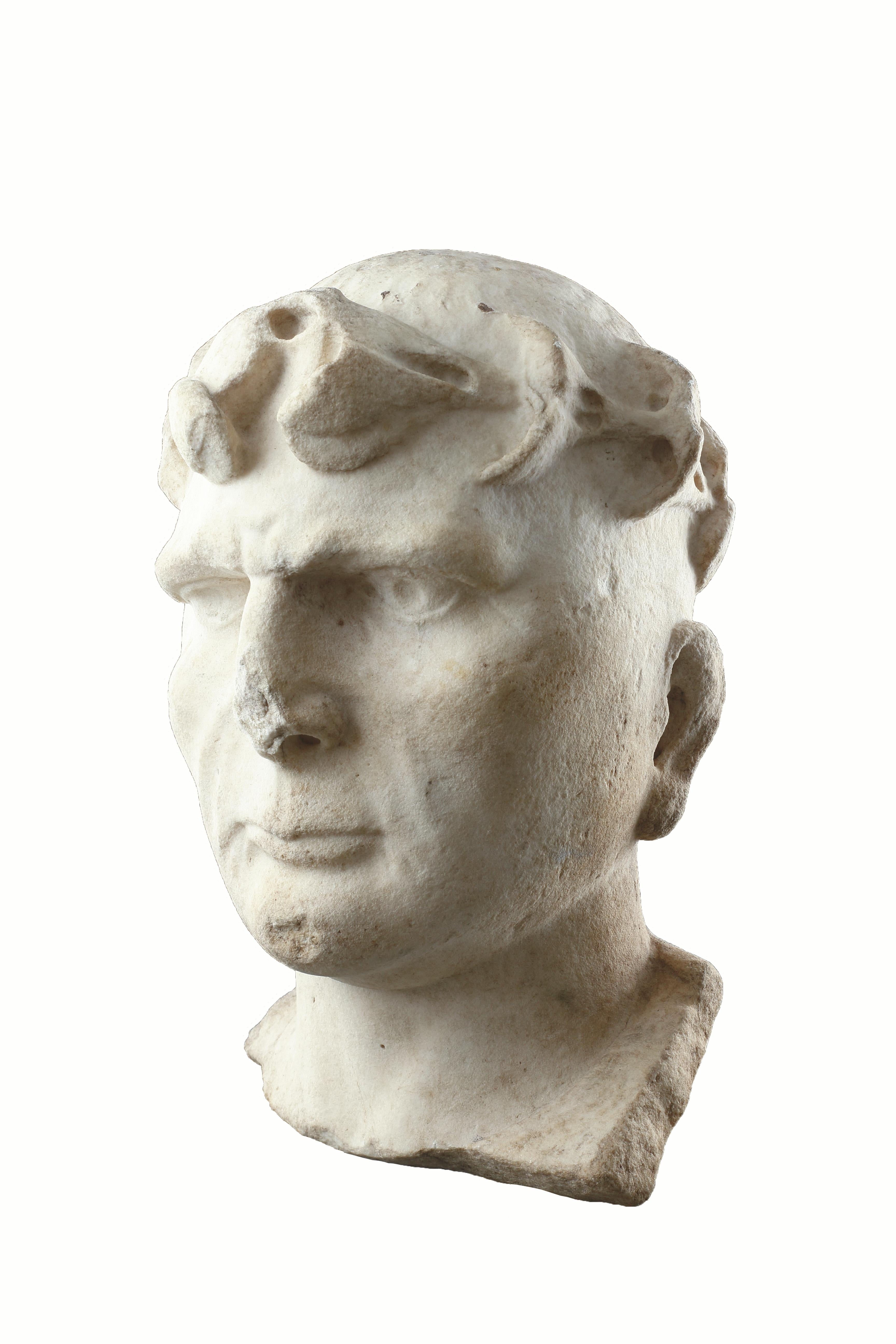 An Over Life-Size Powerful Roman Male Portrait Head of Constantine the Great (c.272 - 337) 
Wearing the ‘Imperial Oak Wreath’ the decorative border of his ‘tunic’ can still be clearly seen on the left hand side 
Marble 
Italy 
Early 4th Century AD