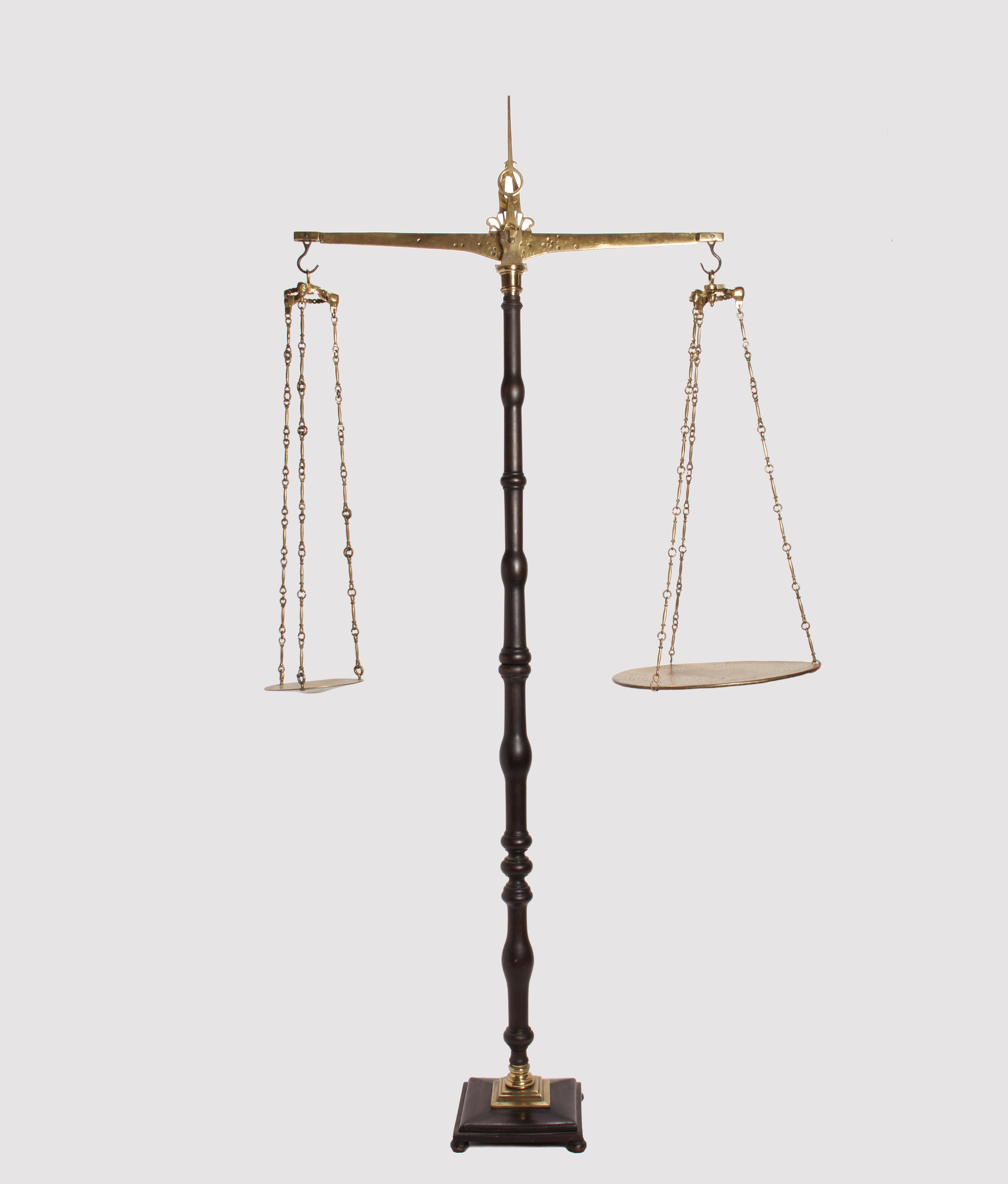 Ancient scale for weighing silk. Over a square wooden base weighted with lead with brass plaque and connecting element rise the tall wooden central part, made out of wood, with moved profile and black lacquered. Overall the arm of the scale, the