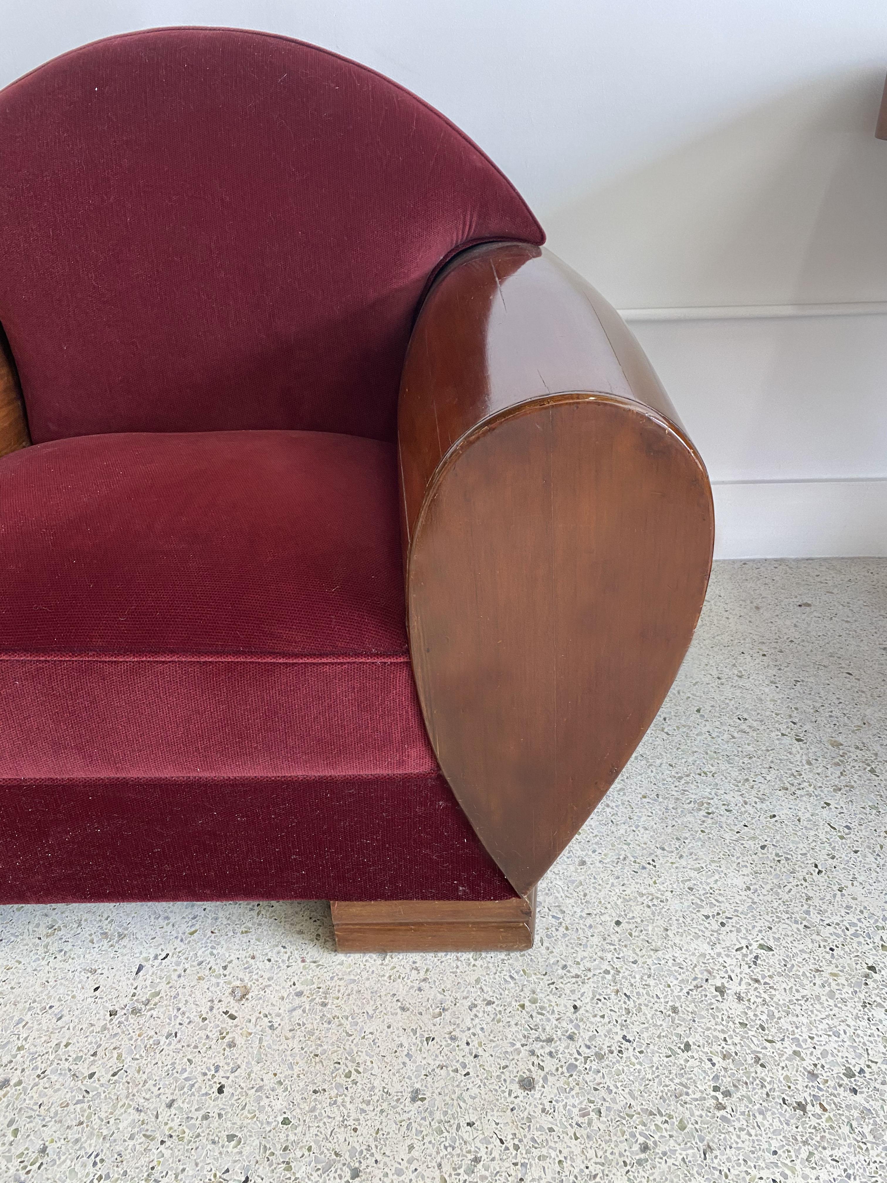 The arched back and upholstered seat within a mahogany framework.