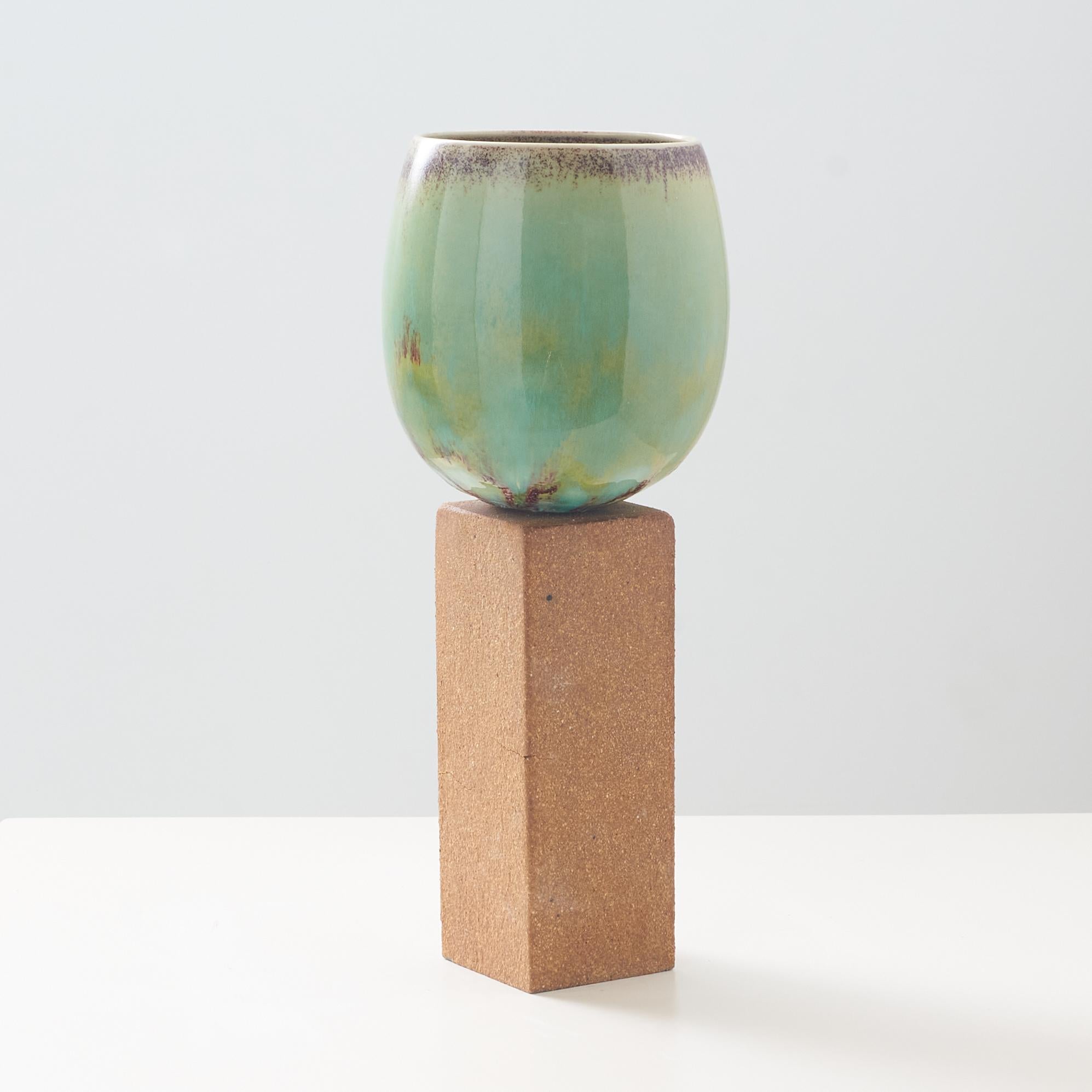 Swedish An ovoid vase with green glaze on tall stone base by Stig Lindberg