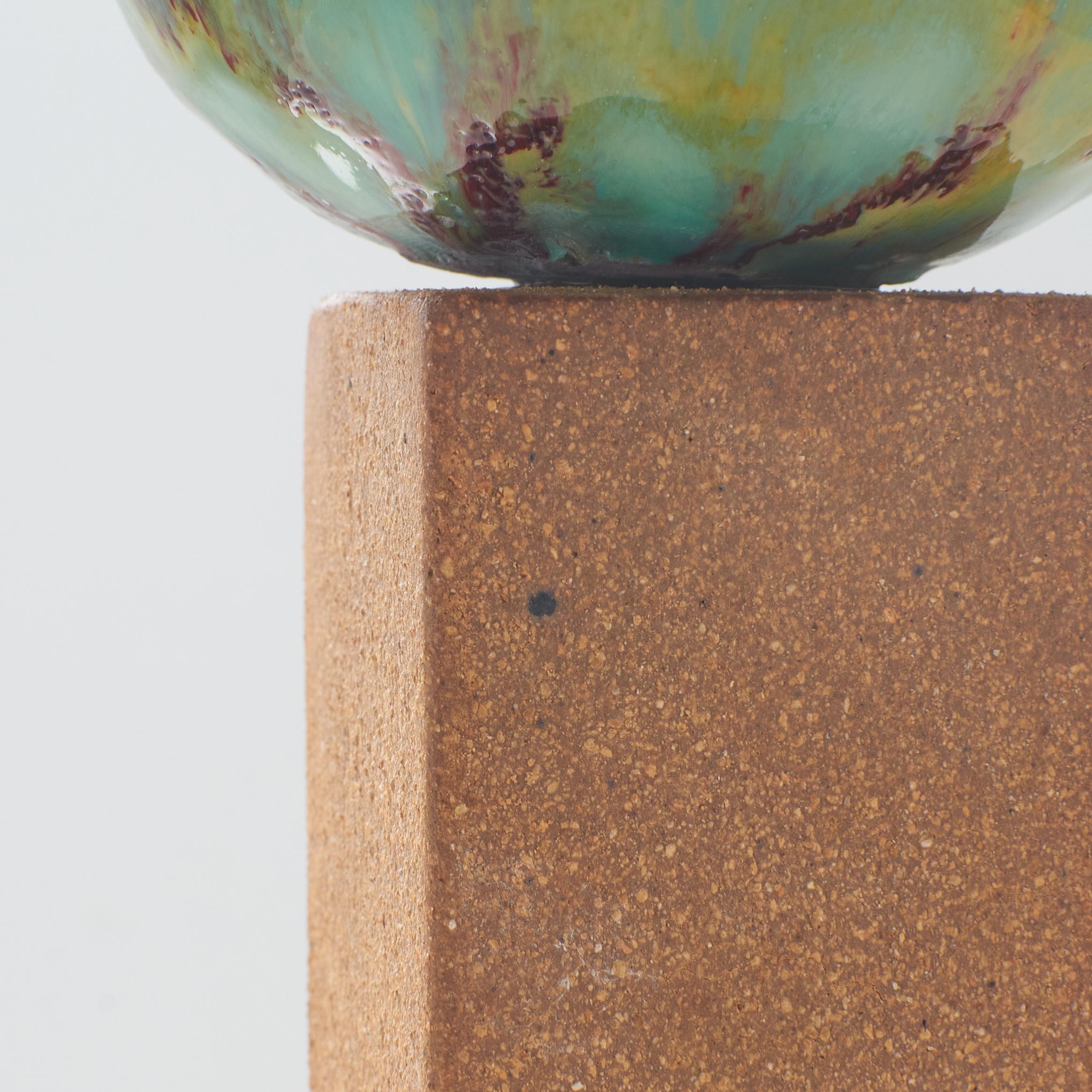 Mid-20th Century An ovoid vase with green glaze on tall stone base by Stig Lindberg