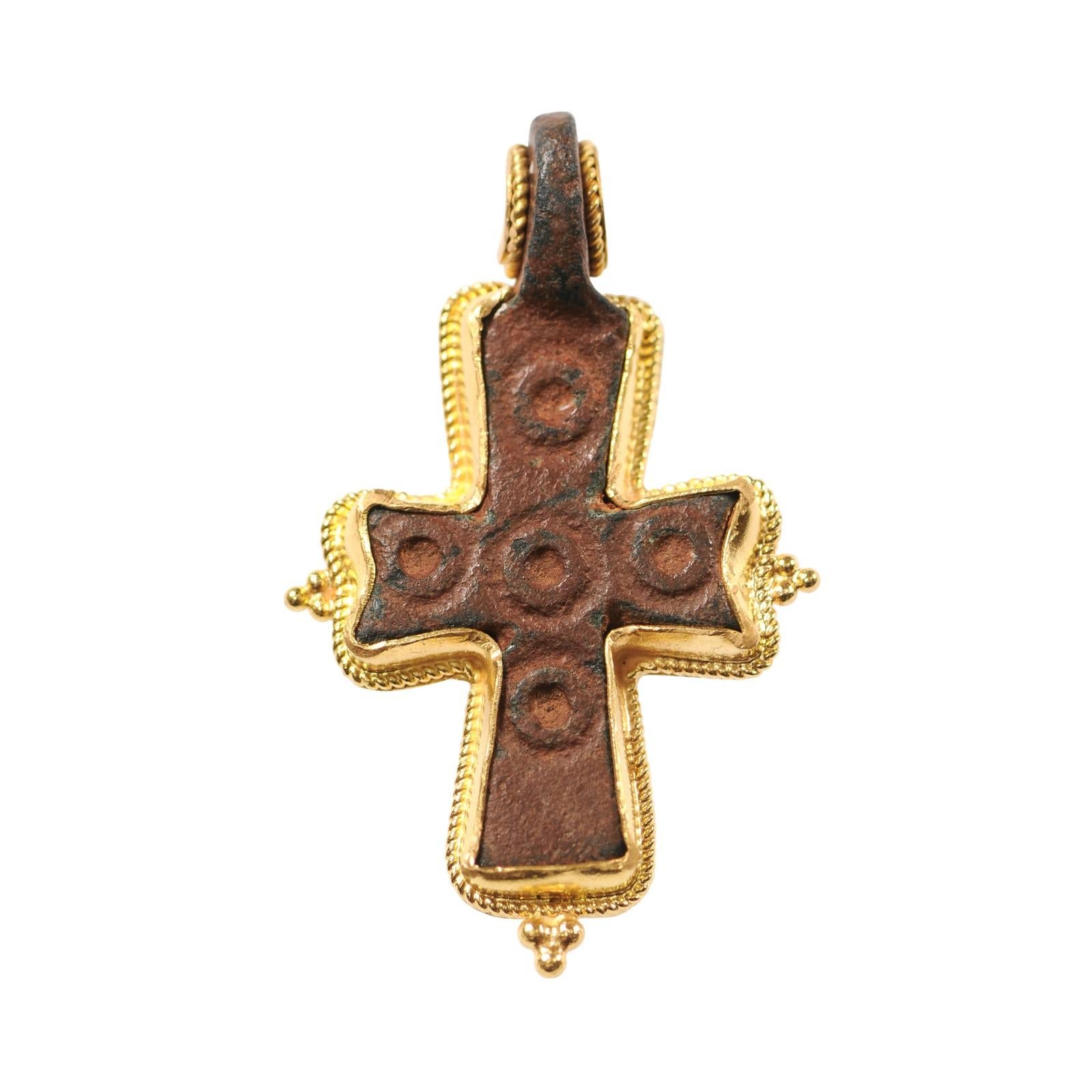 Pendentif en forme de croix en bronze avec balle fixe, datant de l'époque byzantine et orné d'une délicate décoration en or 21K. Cette croix en bronze a été créée à l'origine par moulage à la cire perdue, puis les autres décorations sur le dessus