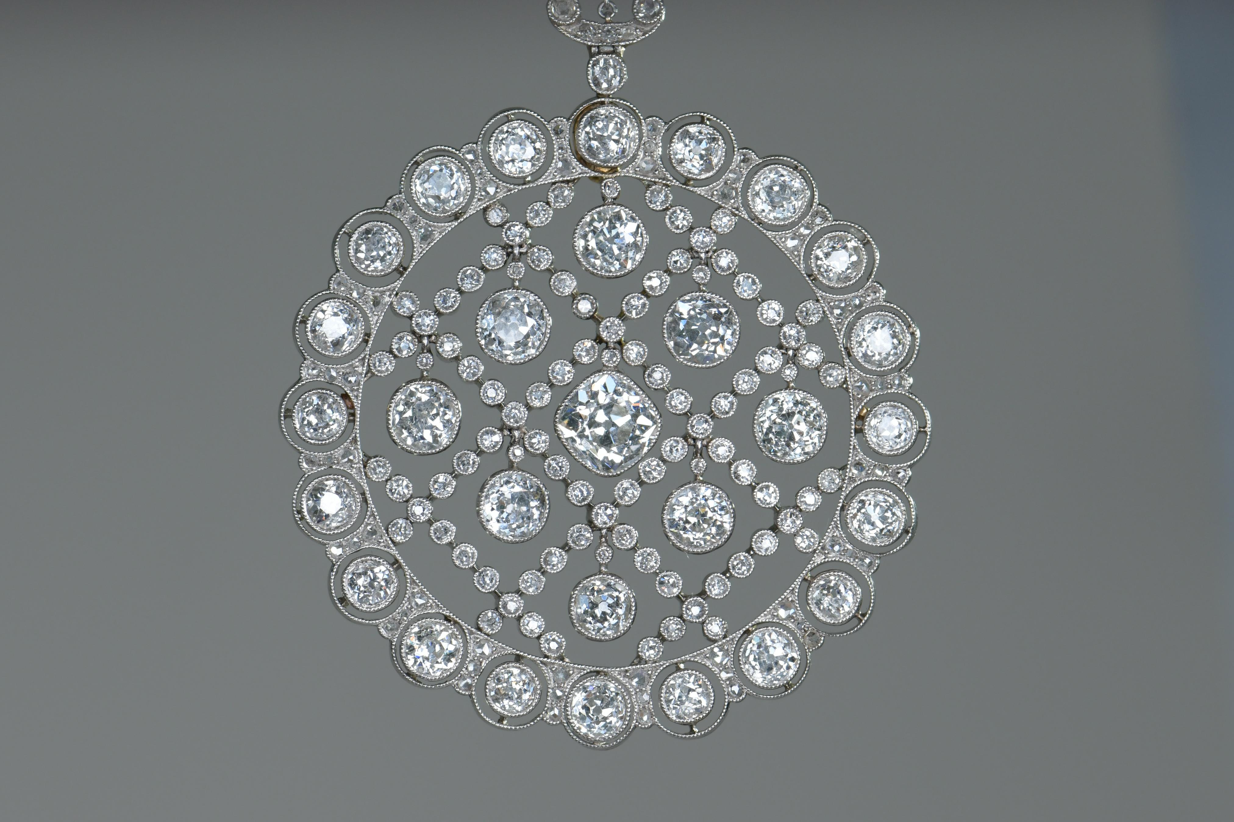 An exceptional Edwardian Belle-Epoque pearl and diamond sautoir, the sautoir comprising a long mesh chain of natural seed pearls diamond pendant, this openwork of foliate openwork design, with central circular pendant drop, setting with nine