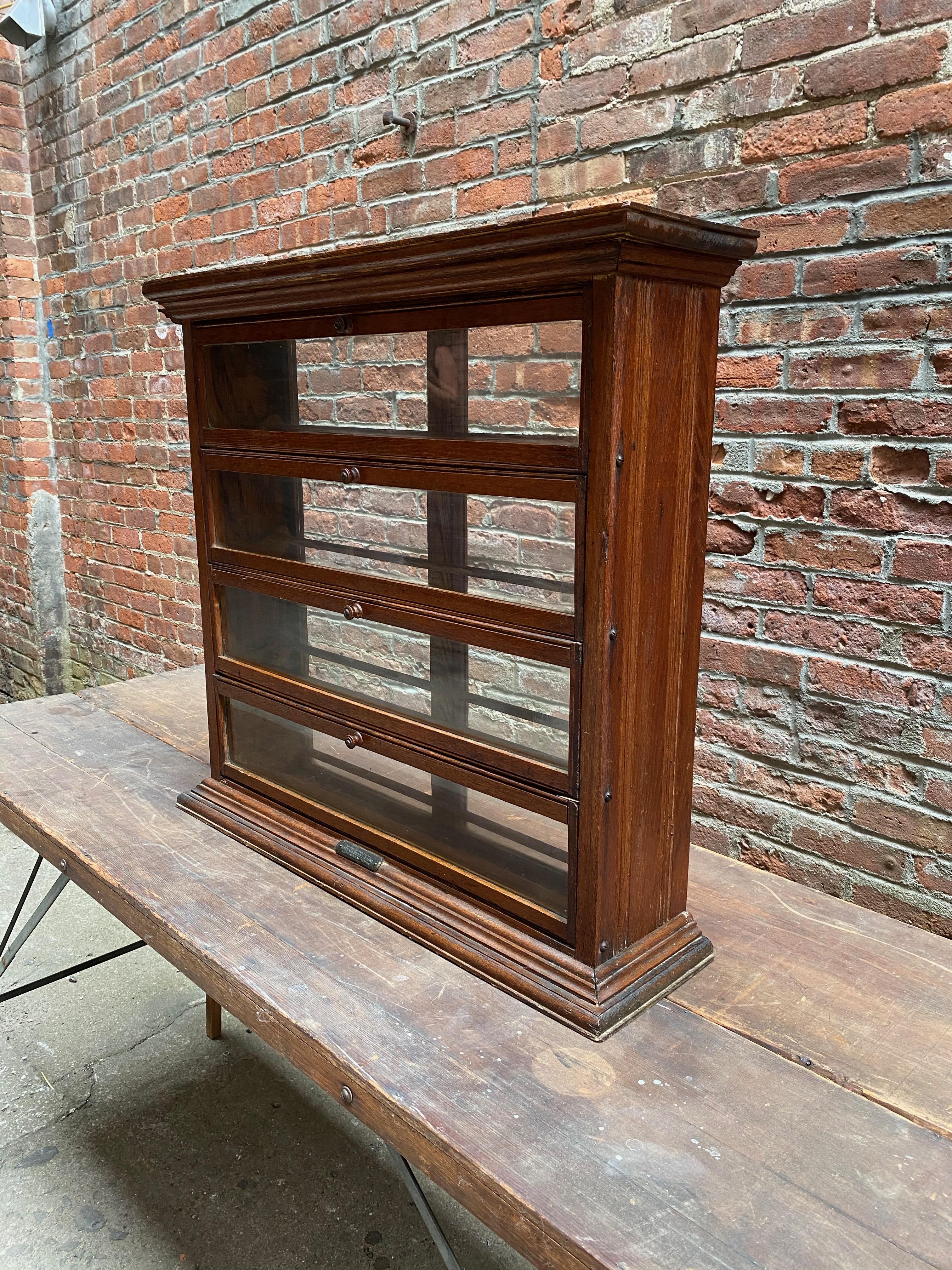 A.N. Russel & Sons oak and glass spool display cabinet. Old counter top general or dry goods store showcase. Solid oak construction with glass panel front and back. Four pullout / pull-out and drop down panels with dowel construction interiors.