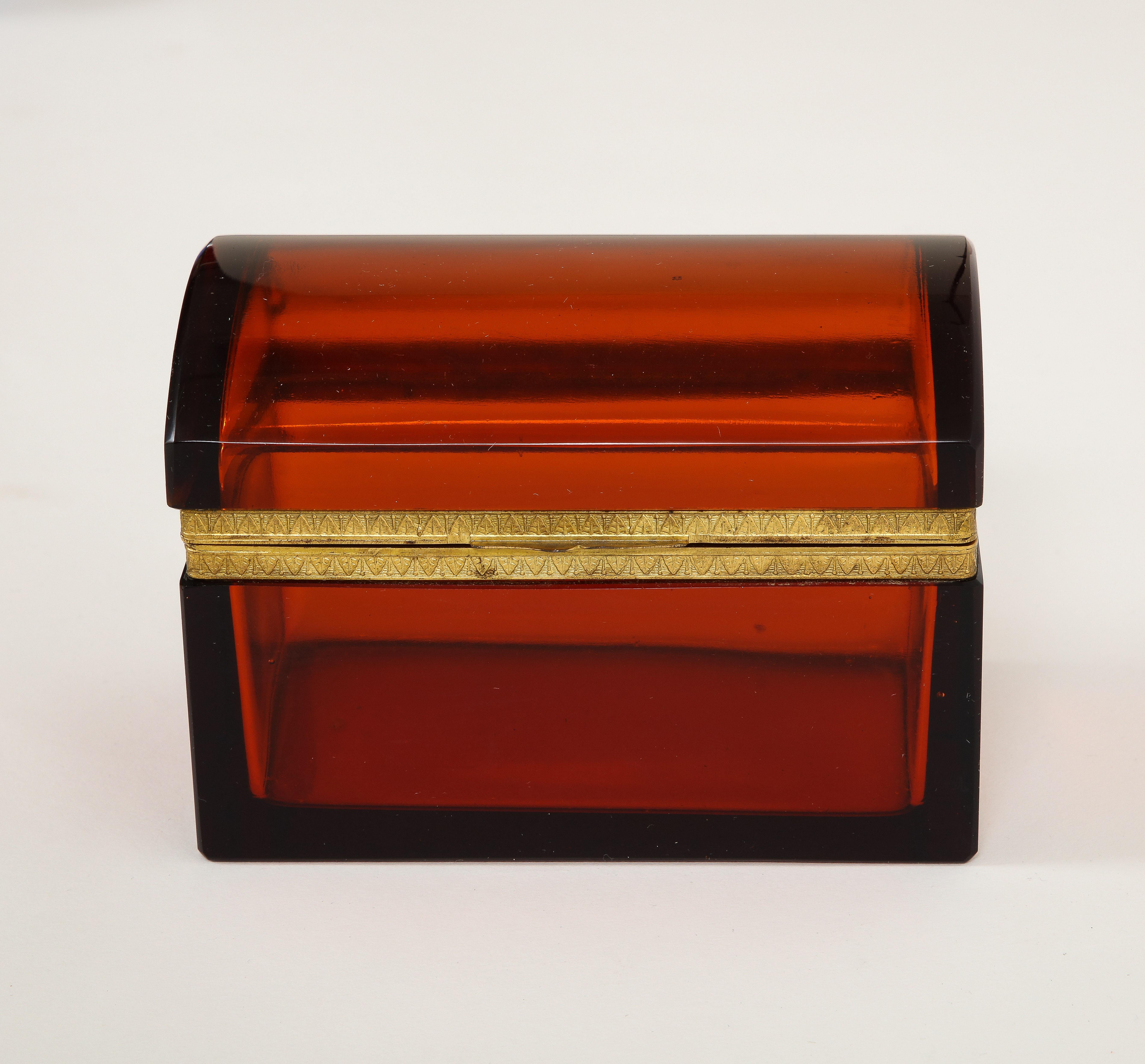 Boîte à cristaux orange/rouge du 19e siècle, montée sur bronze doré. La boîte est composée de deux sections de cristal français orange/rouge qui sont montées sur un fabuleux loquet en bronze doré. Le bronze de la biche est magnifiquement ciselé et
