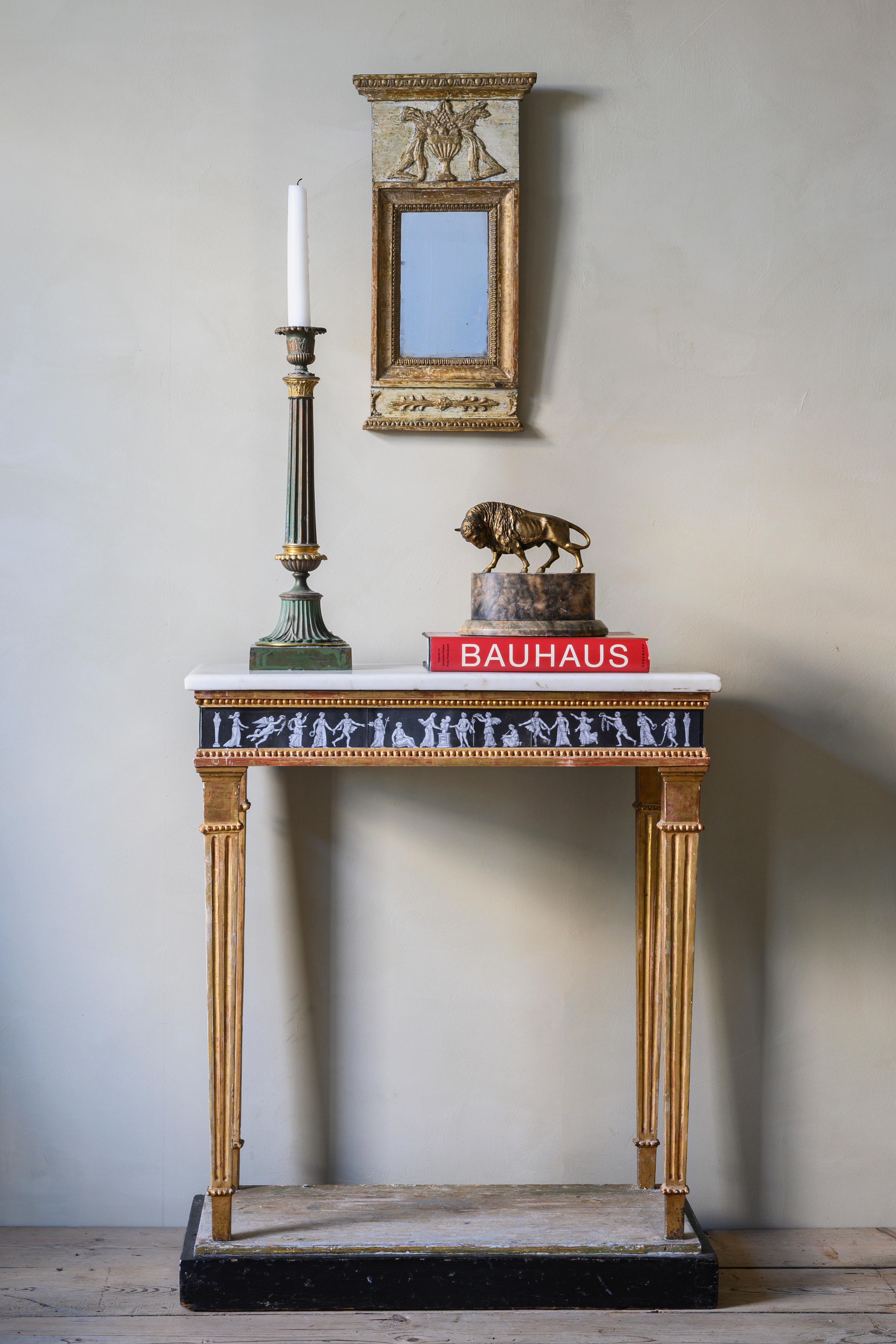 Une inhabituelle et belle table console en bois doré de style gustavien et début Empire du 19e siècle, avec plateau en marbre de Carrare et gouache, vers 1815. Très inhabituel avec la gouache qui s'étend jusqu'aux bords, ce qui ajoute à l'aspect