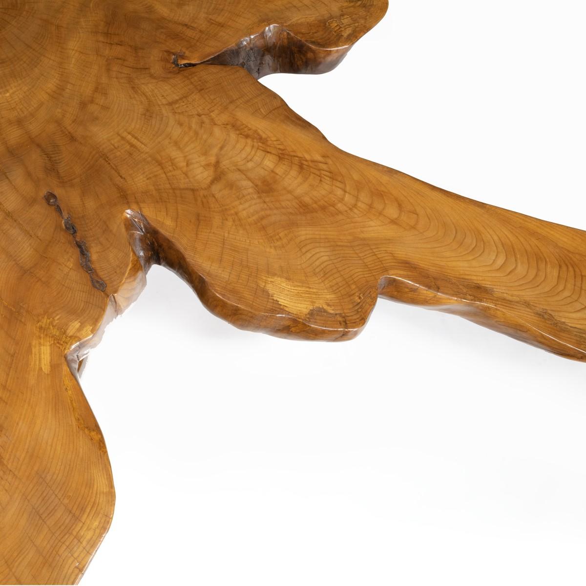 Ein ungewöhnlicher und attraktiver Mitteltisch von Maxie Lane, geschnitzt aus massiver Ulme mit einer unregelmäßig geformten Platte, die von vier gebogenen Beinen und einer runden kreuzförmigen Bahre getragen wird. Englisch, um 1970.

 
Fußnote: