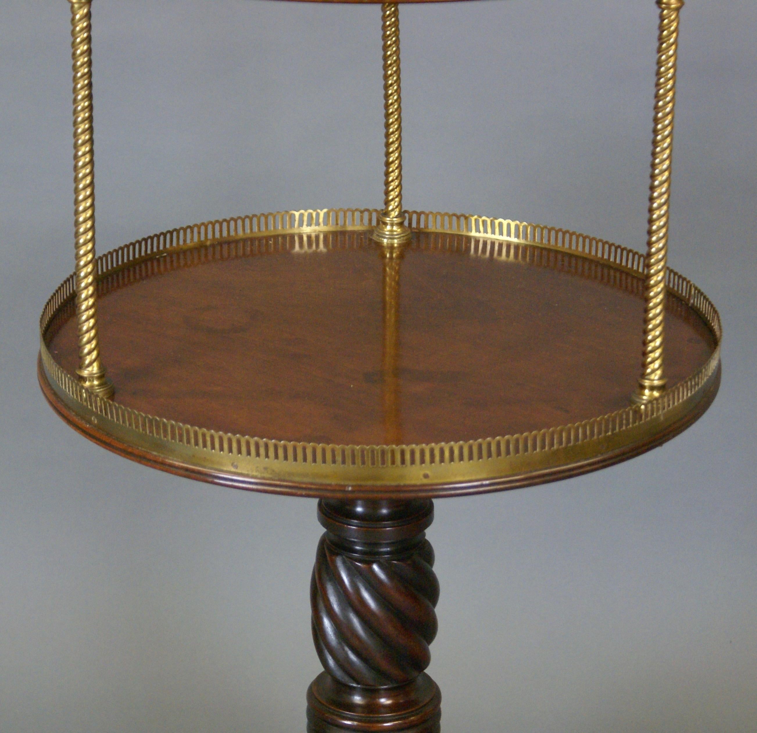 An unusual and Attractive Regency dumb waiter. In dense mahogany and standing on a tripod base with acanthus leaf carved and molded sabre legs terminating in brass castors supporting twisted and reeded column. The two tiers are separated by brass