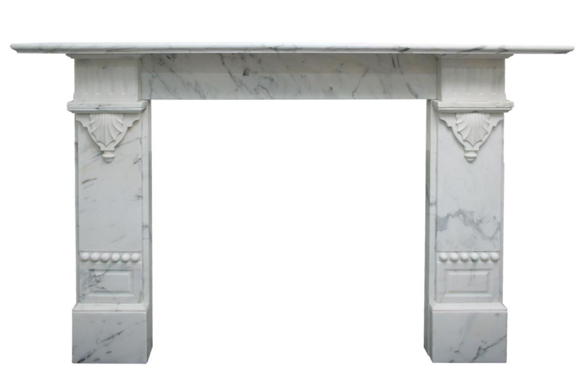 An unusual antique late 19th century Victorian fireplace surround in beautifully figured Calacatta marble with fluted square capitals above further applied carved detail. 

Pictured with an original Victorian cast iron grate, sold separately.