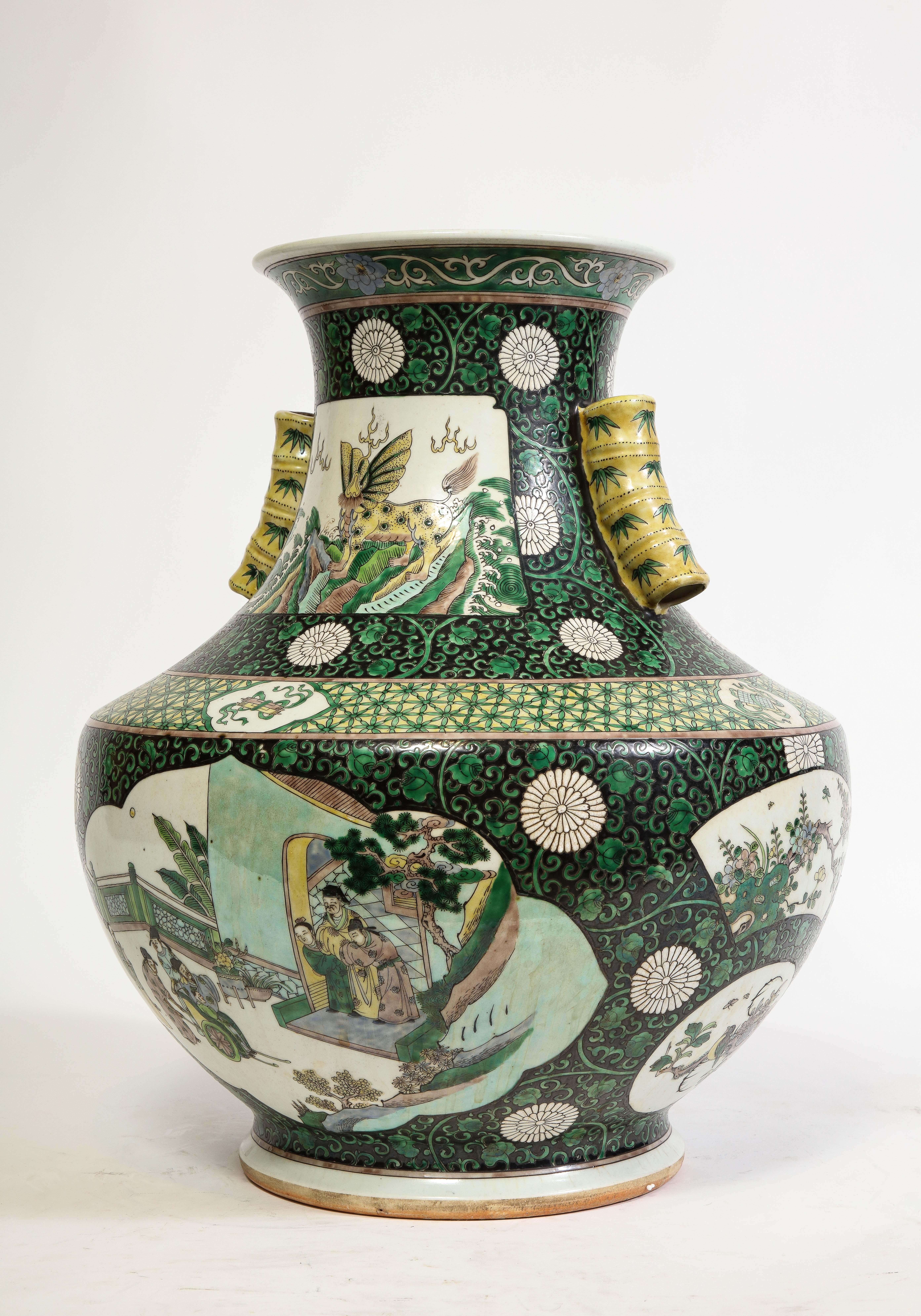 An Unusual Chinese Famille Vert Porcelain Vase with Bamboo Handles  The white stylized cloud-like section on the main body of the vase features a stunning hand-painted scene in yellow green, black, and green hues, depicting a gathering of dynamic