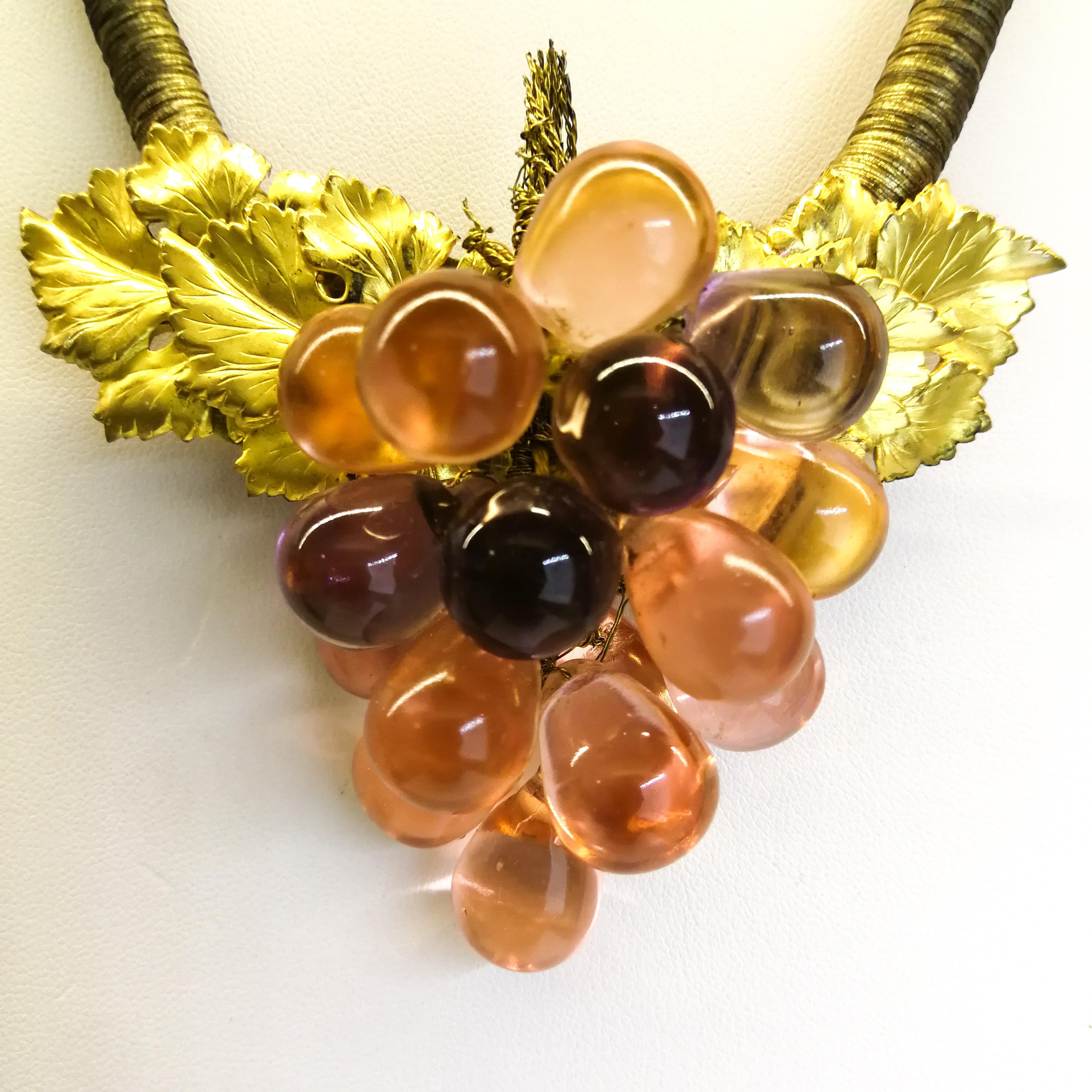 A highly unusual pendant necklace, from the 1920s, with a soft, subtle colour way, a gentle gilding mixed with transparent peach glass 'grapes', all mounted on a graduated necklace that is 'bound' in faded gilt bullion thread, with a distinctive