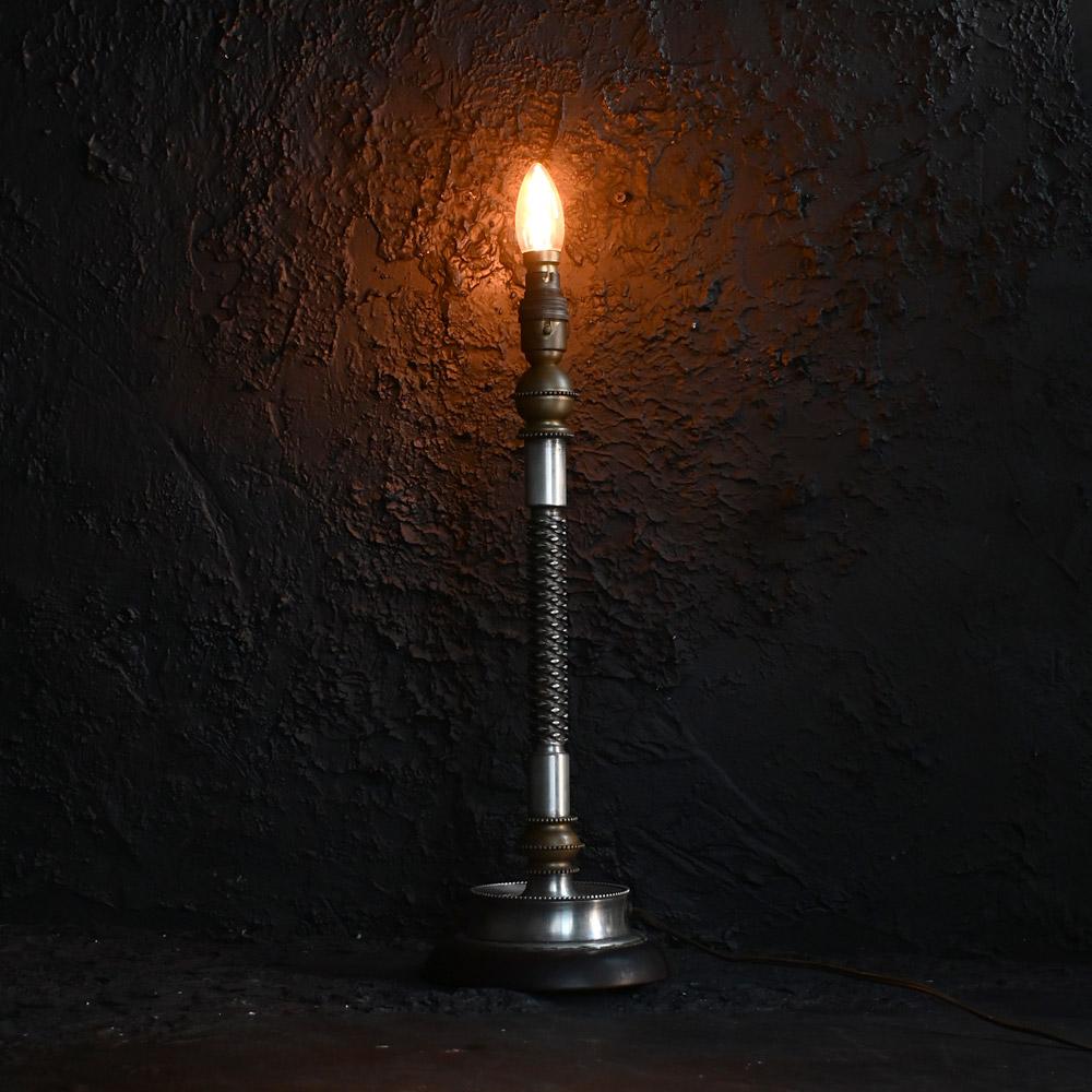 An unusual Early 20th century American table lamp

Stood on a solid bakerite base, this very unusual American machinist movement style table lamp is made from solid heavy metal sections including brass. The central shaft reminds us of some form of a