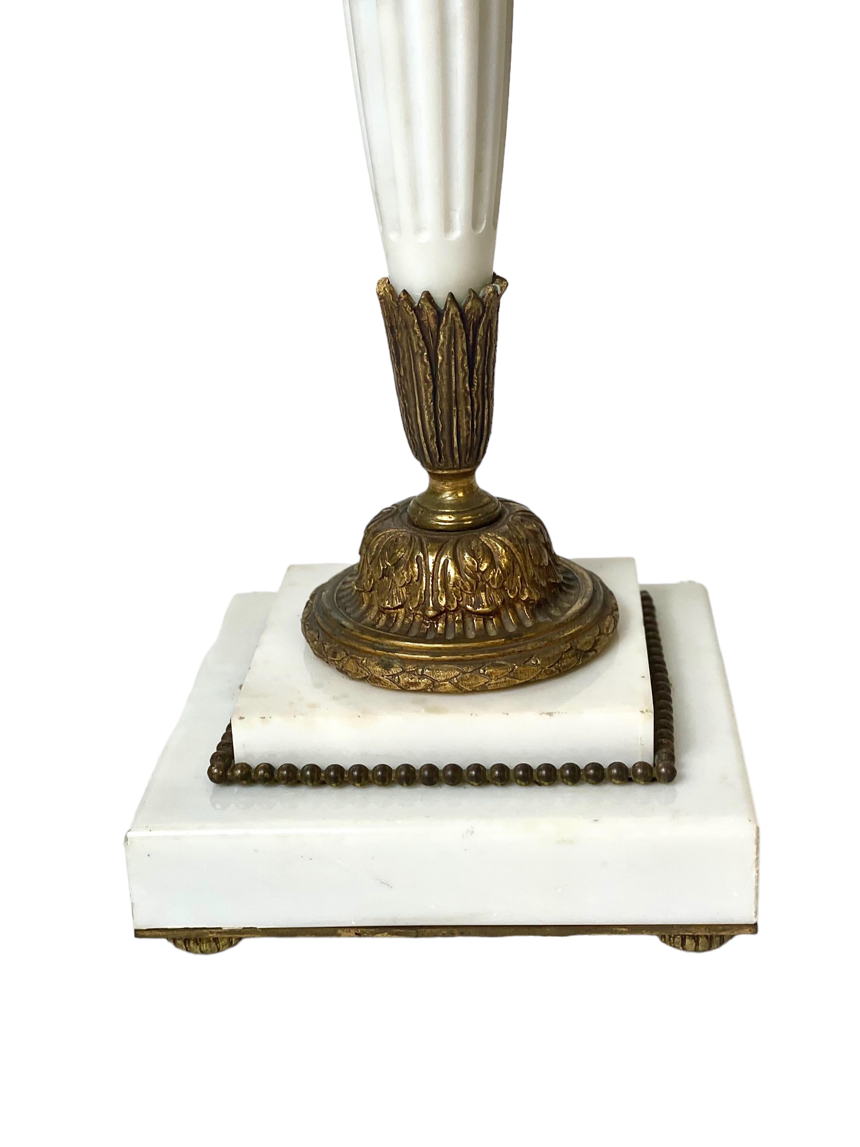Eine ungewöhnliche und imposante Tischlampe im Empire-Stil aus weißem italienischem Carrara-Marmor, mit kunstvollen Verzierungen aus vergoldeter Bronze. Die Leuchte ist in Form eines Pfeilköchers gestaltet und mit bronzenen Fletchings