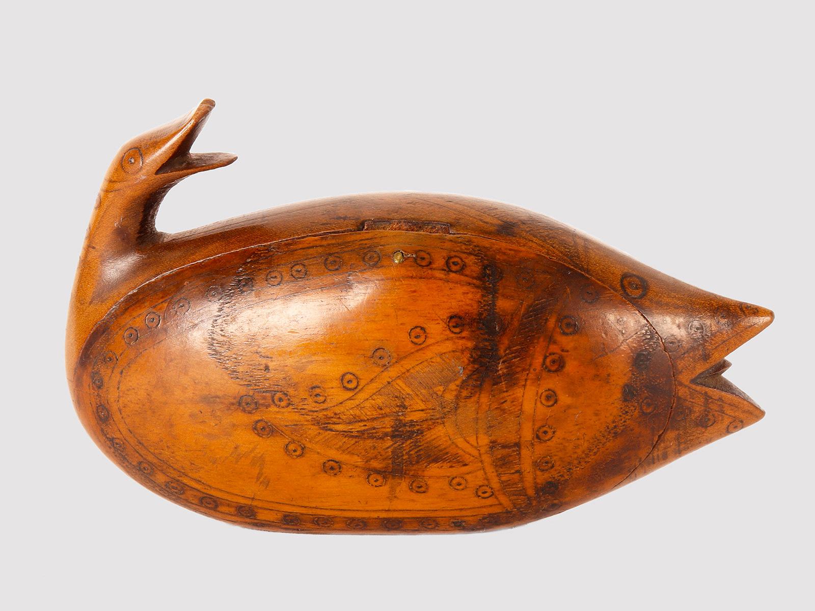 Scandinavian ink decorated treen wood fish shaped snuff box. The fishtail becomes a bird’s head with an open beak. This Scandinavian snuff box was made during the mid to late 19th century. The box is carved from treen wood and is pen-worked,