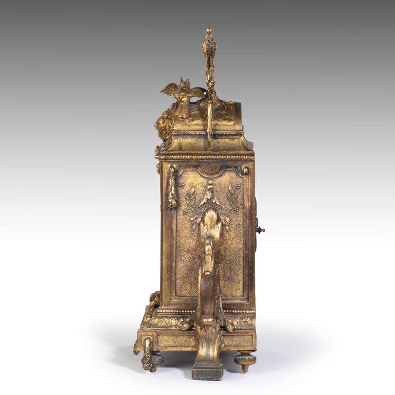 An unusual, French, gilt bronze mantel clock. With elaborate swags over cameos of birds to the top section. Retaining its original glazed enamel timing figures.
      