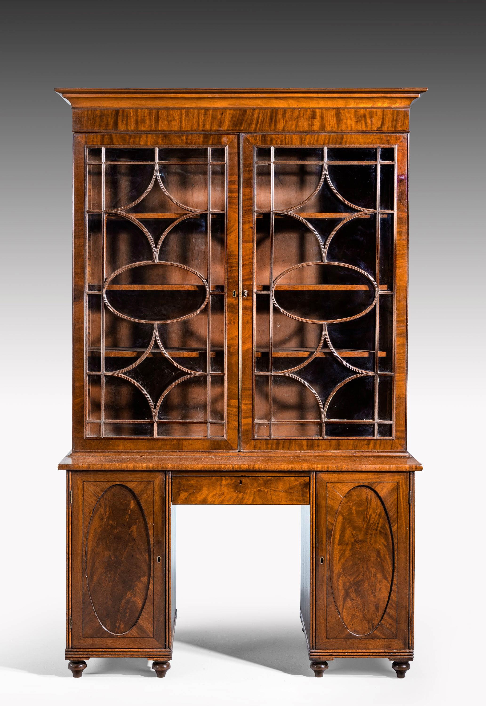 An unusual George III period mahogany bookcase, the base section with a kneehole. Original astragal glazing
