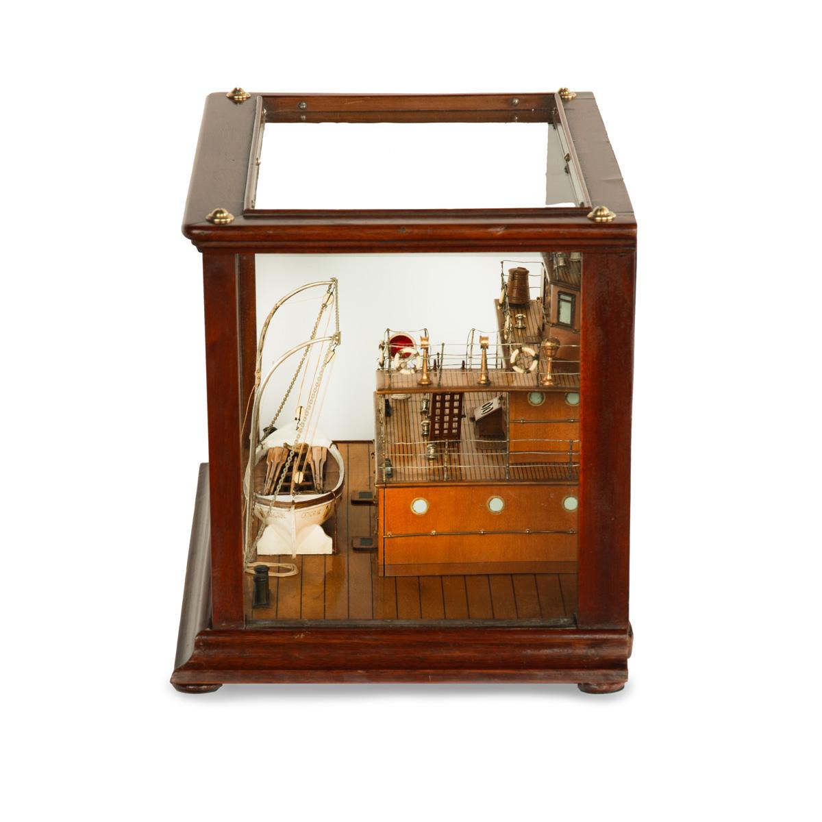 Une maquette inhabituelle à fond miroir d'une section du navire à vapeur Catherine Govan, de forme rectangulaire, montrant trois ponts en buis doublé, un canot de sauvetage en bois sculpté dans des bossoirs argentés, équipé de traverses et d'avirons