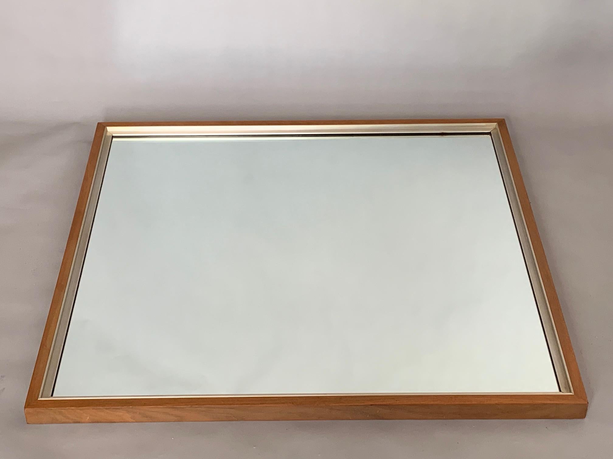 An unusual Paul McCobb mirror in walnut and aluminum from the Calvin collection. Measures approximately 34x36