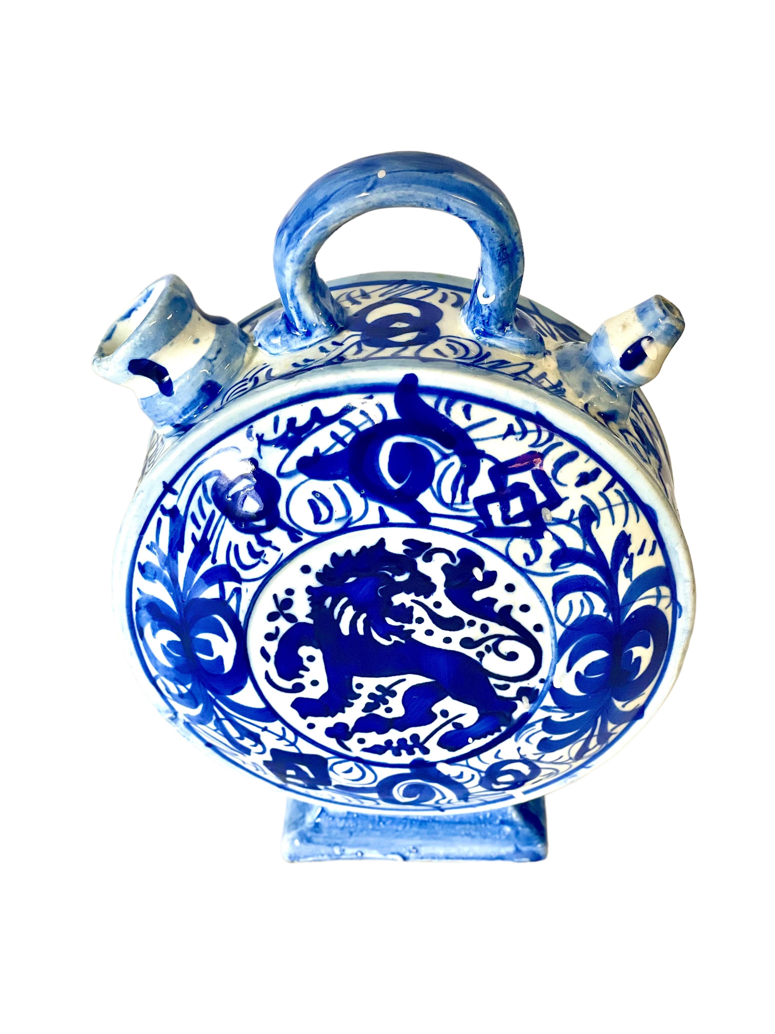 A very unusual and charming earthenware 'Chevrette' cruche, or water pitcher, beautifully hand painted with fantastical animal imagery in vivid blue and white. Commonly used for transporting drinking water by agricultural workers, the design of this
