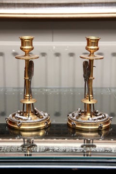 Una coppia insolita di candelieri “marziali” in bronzo dorato e argentato di Antonio Iu