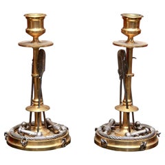Una coppia insolita di candelieri “marziali” in bronzo dorato e argentato di Antonio Iu