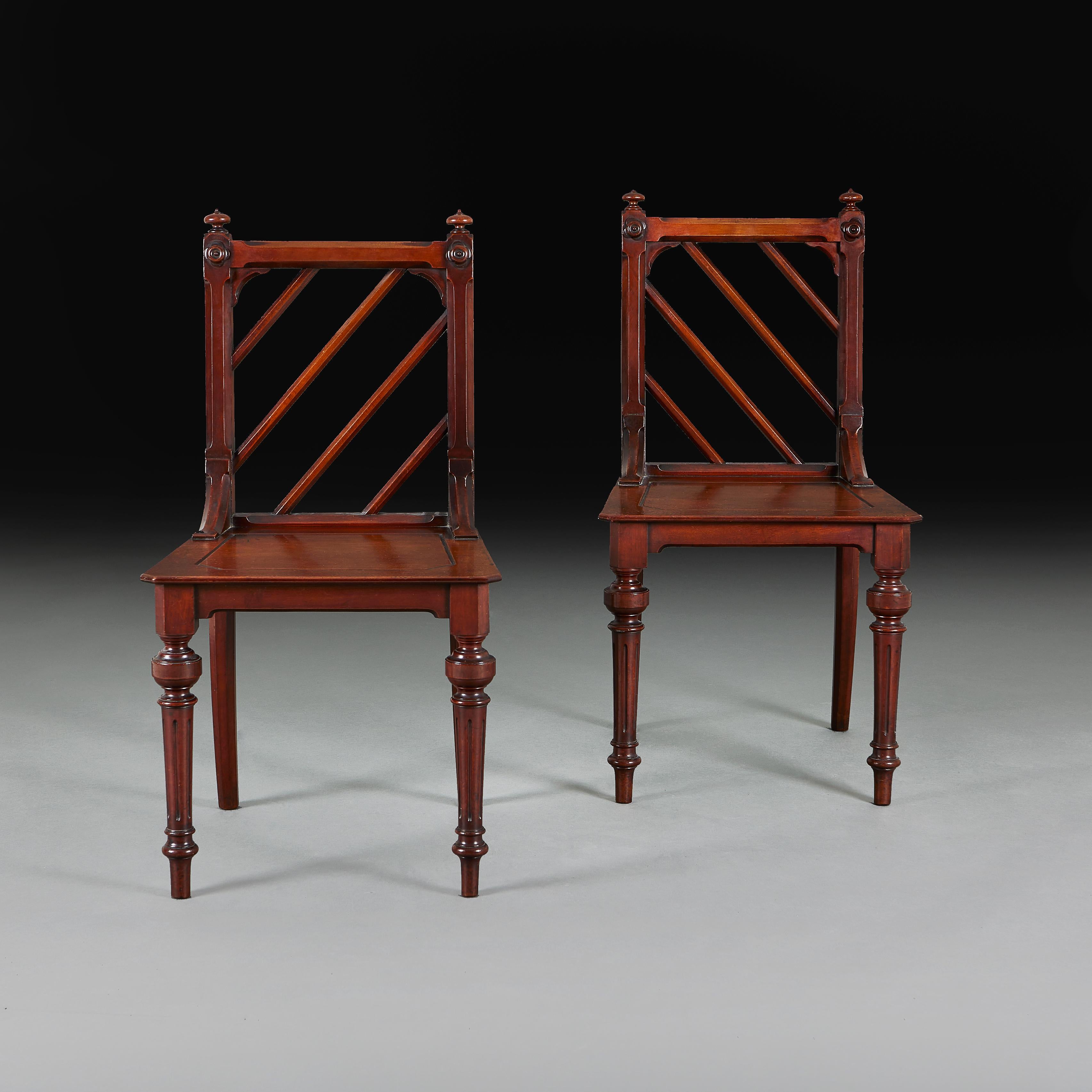 Une paire inhabituelle de chaises de salle en acajou du milieu du XIXe siècle avec des dossiers diagonaux dans le goût chinois, des sièges carrés, le tout soutenu par des pieds tournés.