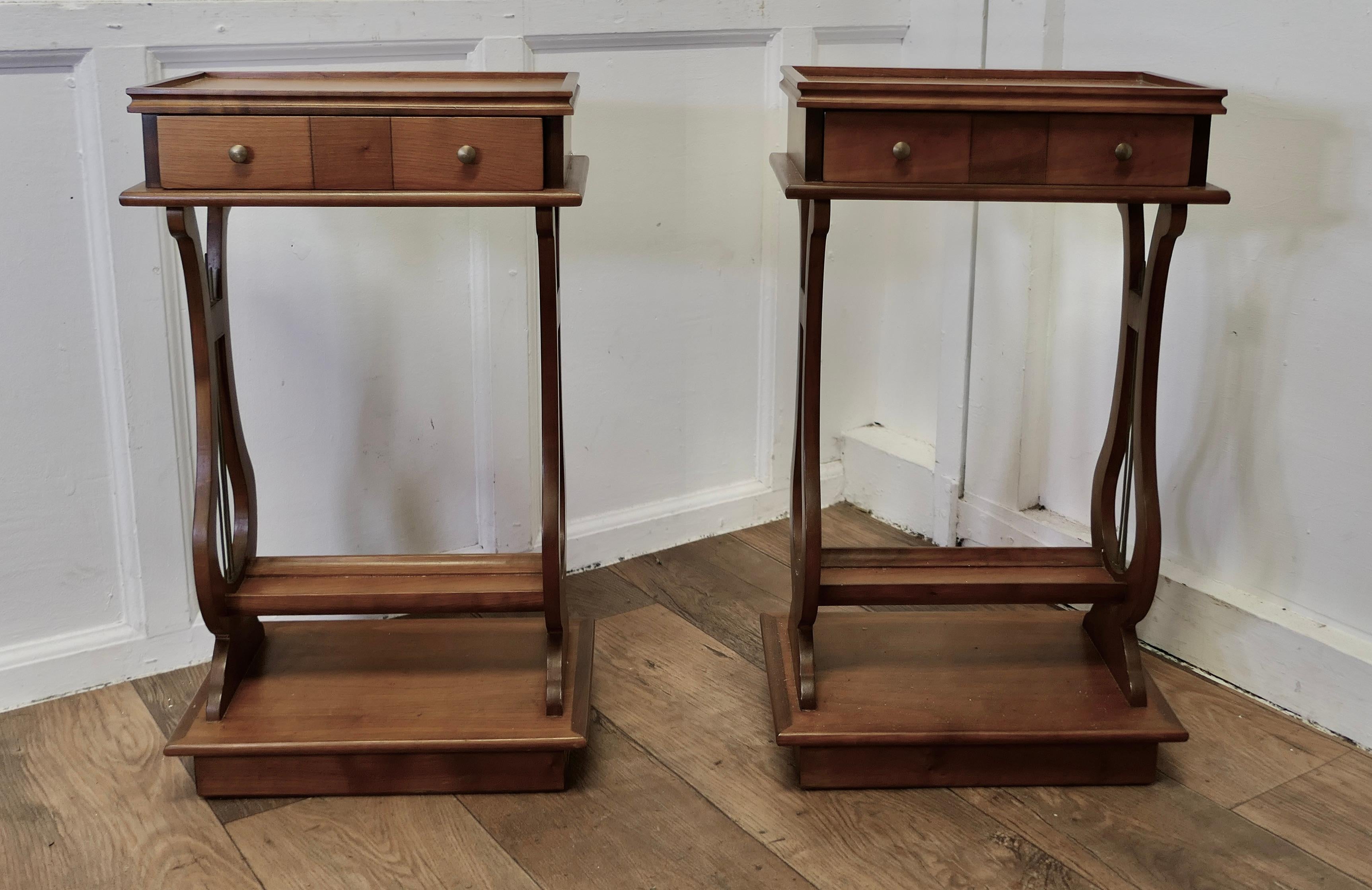 An Unusual Pair of Lyre Ended Cherrywood Lamp or Side Tables 

This is a very attractive pair, the tables have a small gallery around the top with a long drawer below, the legs resemble a Lyre with small brass rods and these are set on a solid