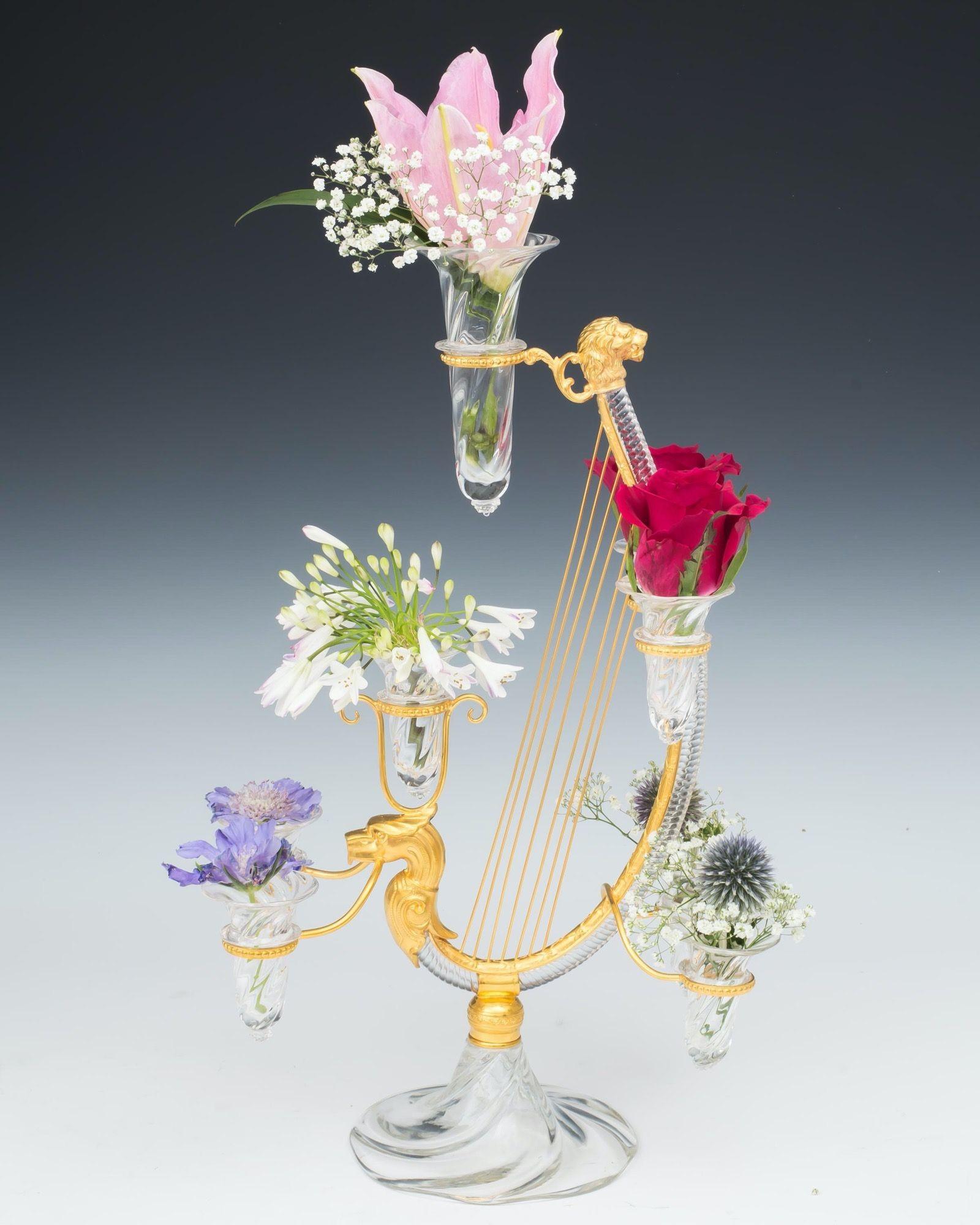 A fine pair of flower epergnes on swirl rib base supporting a rope twist harp mounted with ormolu strings between dragon and lion heads, the harp issuing eight swirl ribbed posy vases with raspberry punts.
Measures: Height 46.5 cm (18 1/4