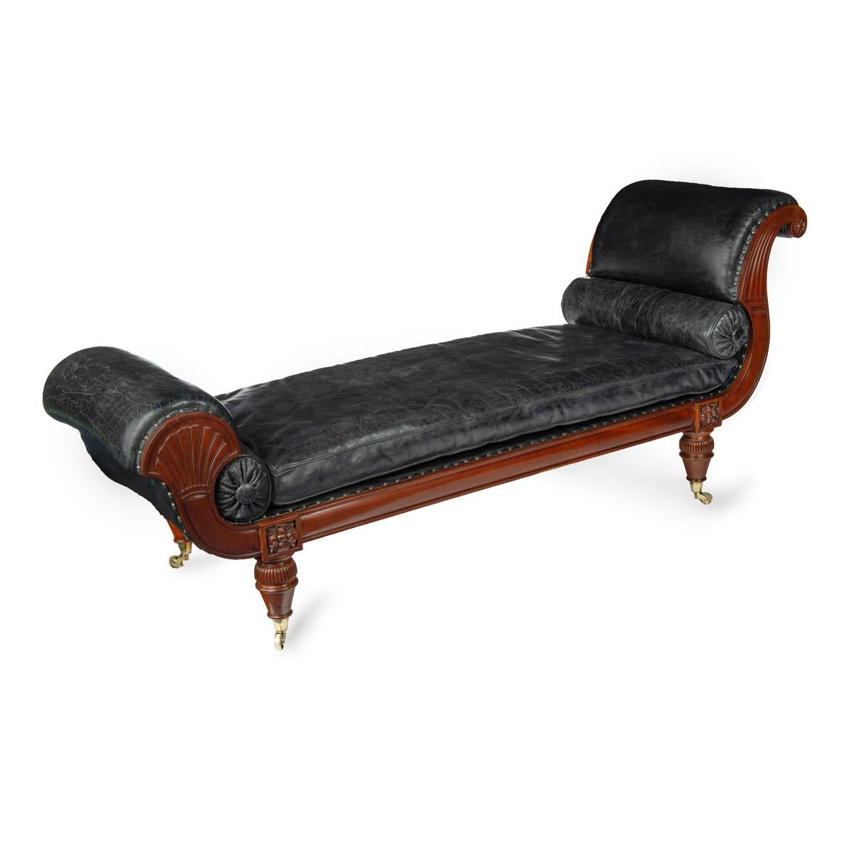 An unusual pair of Regency mahogany day beds in the manner of Gillows, one facing left and the other facing right, each having a scroll and a bolster at one end and lotus fan at the other, raised on tapering legs with gadrooned caps and original